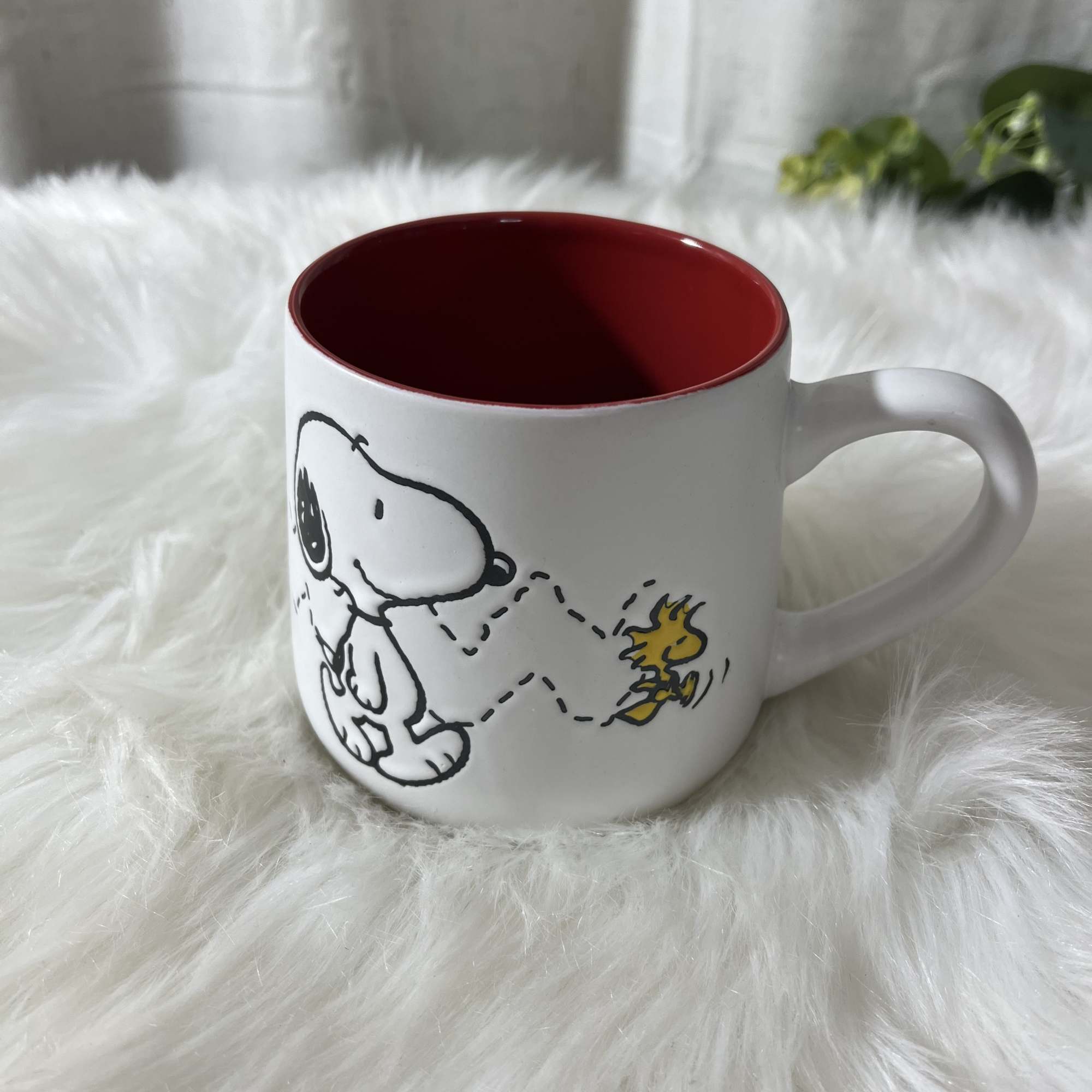 White mug with a red interior and Snoopy graphic