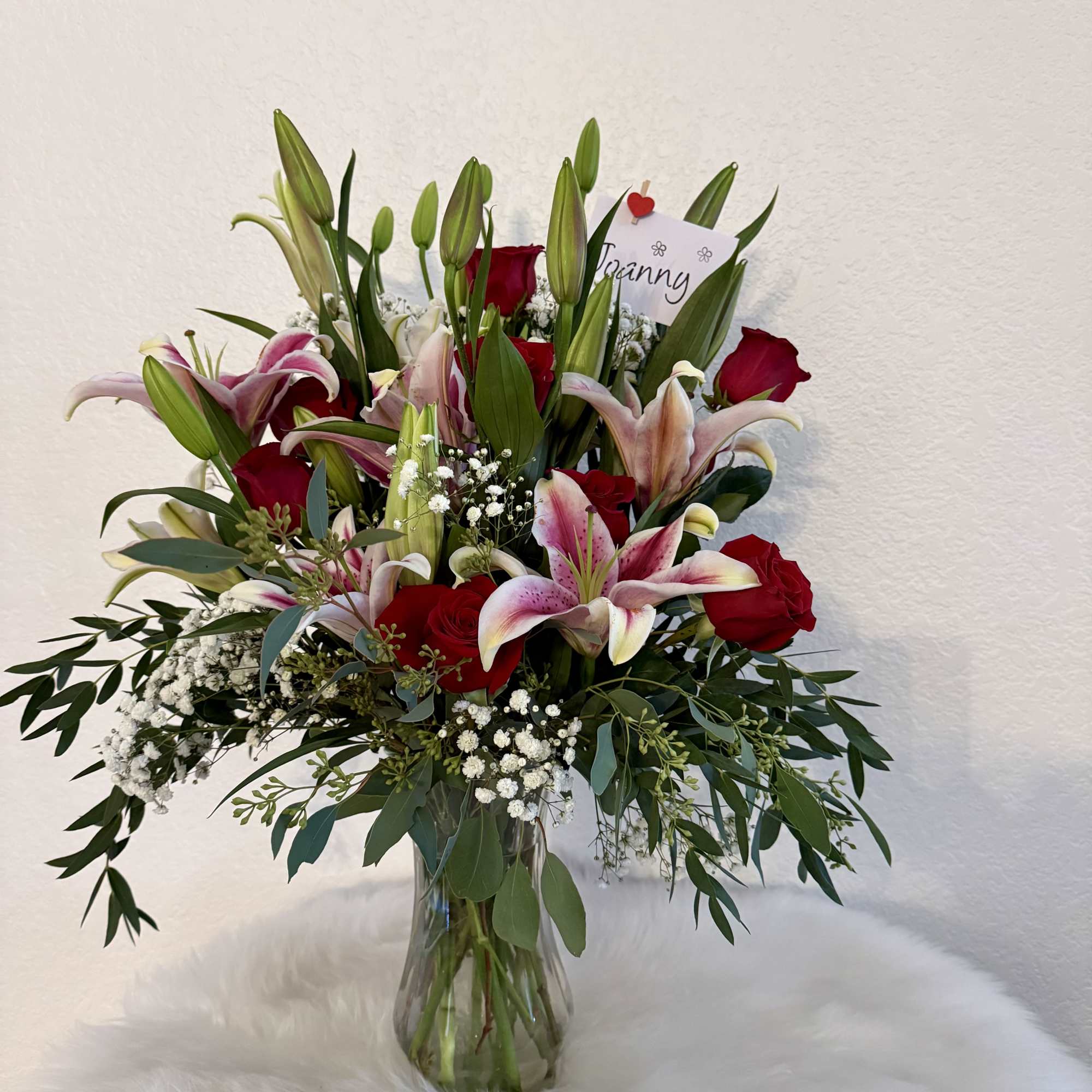 Bouquet of red roses and pink lilies in a glass vase