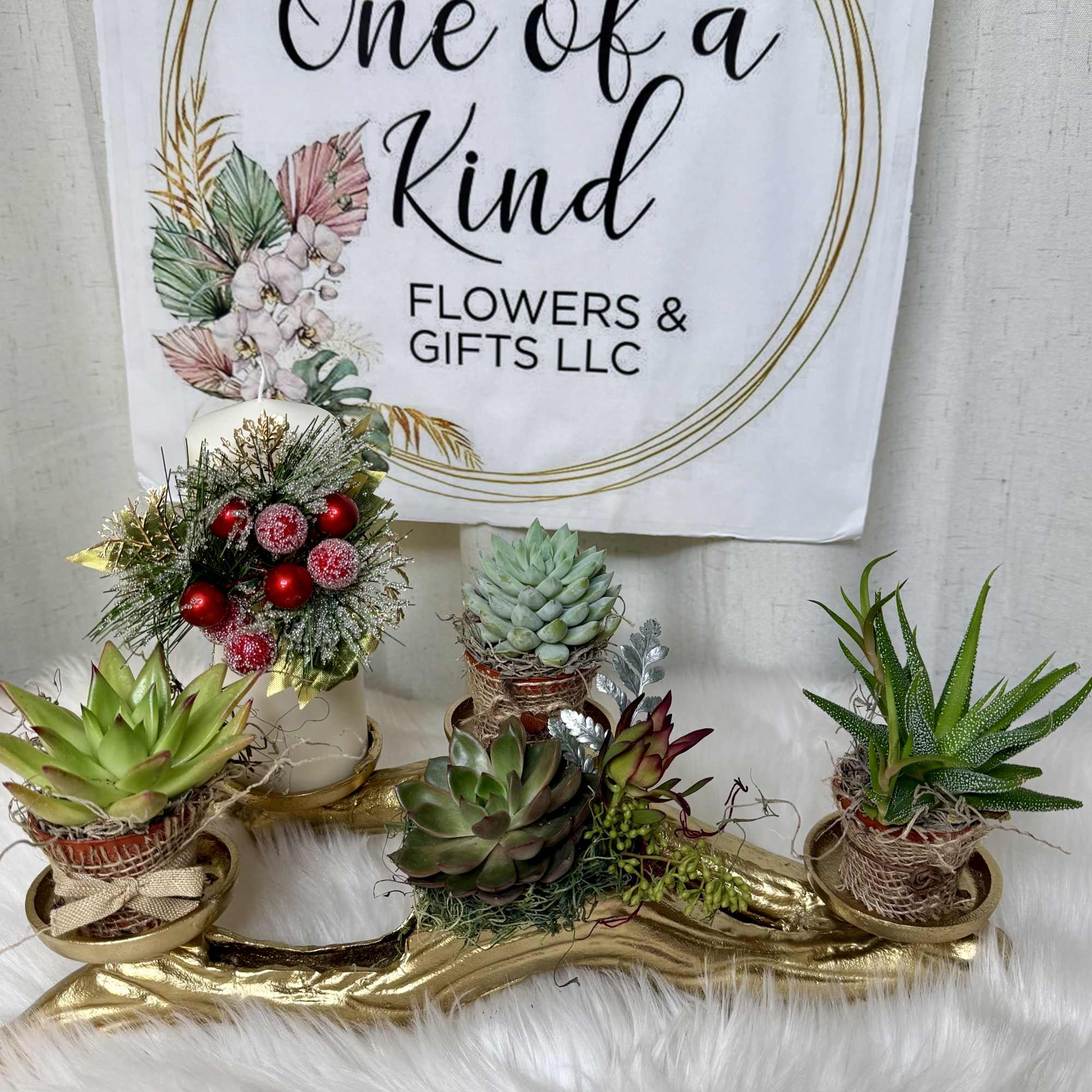 Succulent arrangement with holiday ornaments on a gold tray