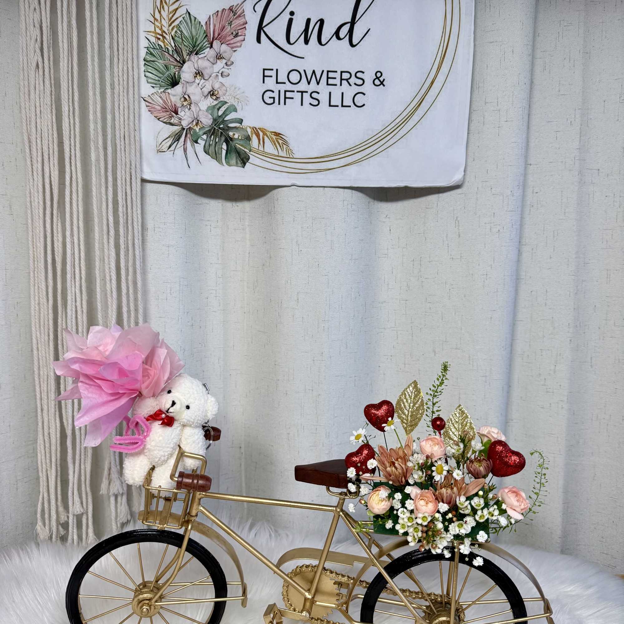 Gold bicycle decor with a small floral arrangement and teddy bear