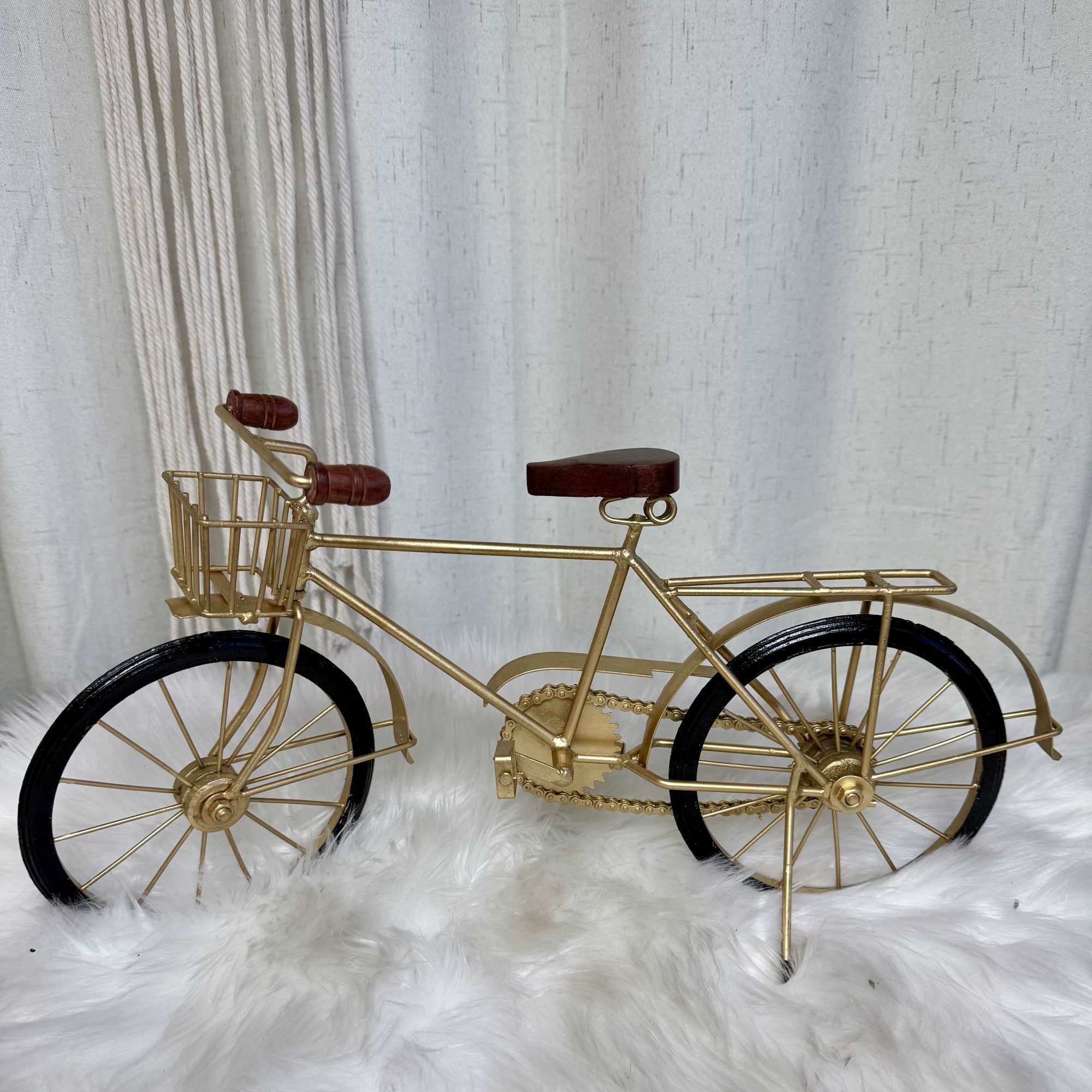 Decorative gold bicycle sculpture with black wheels and a front basket