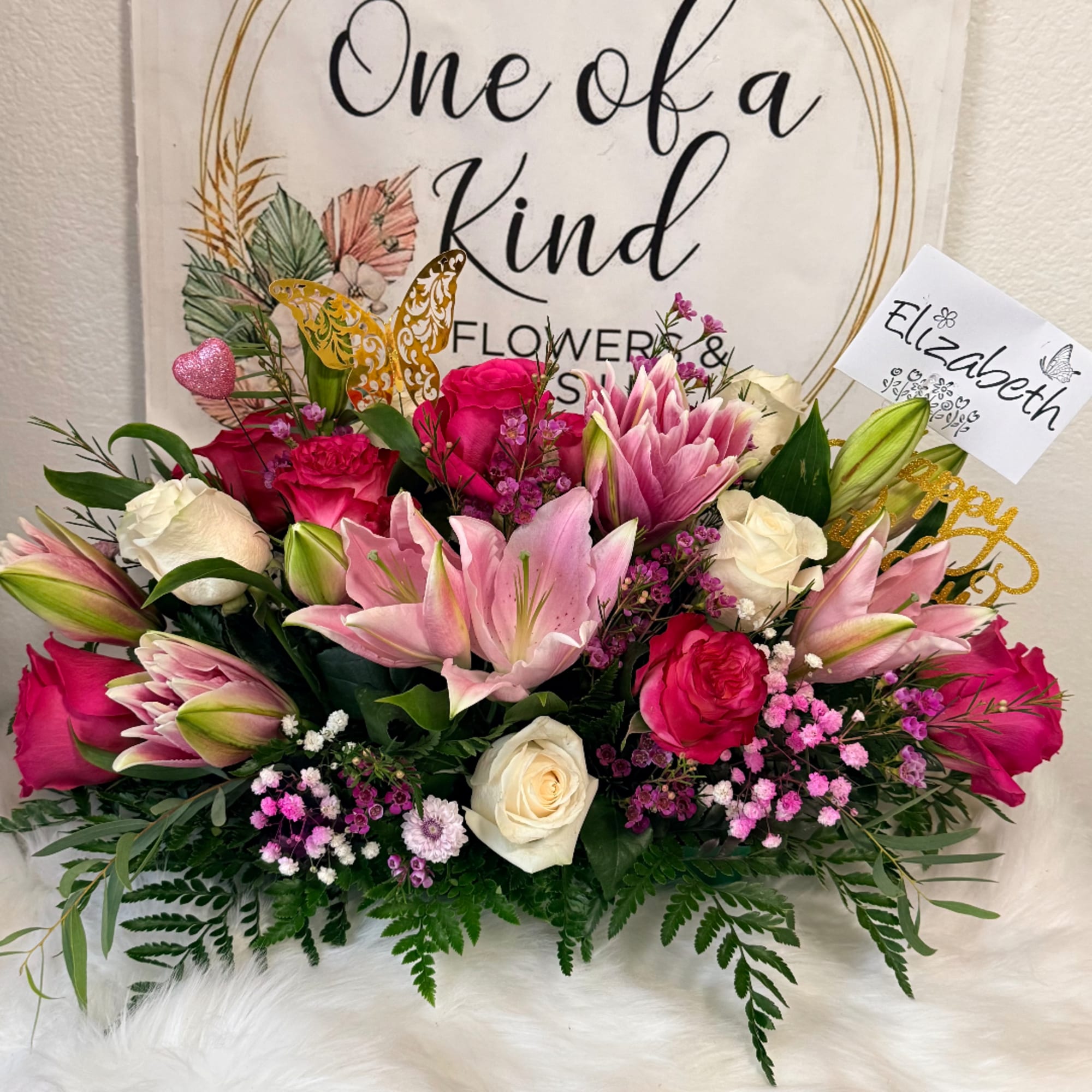 Pink lilies and roses arranged with white roses in a low bouquet
