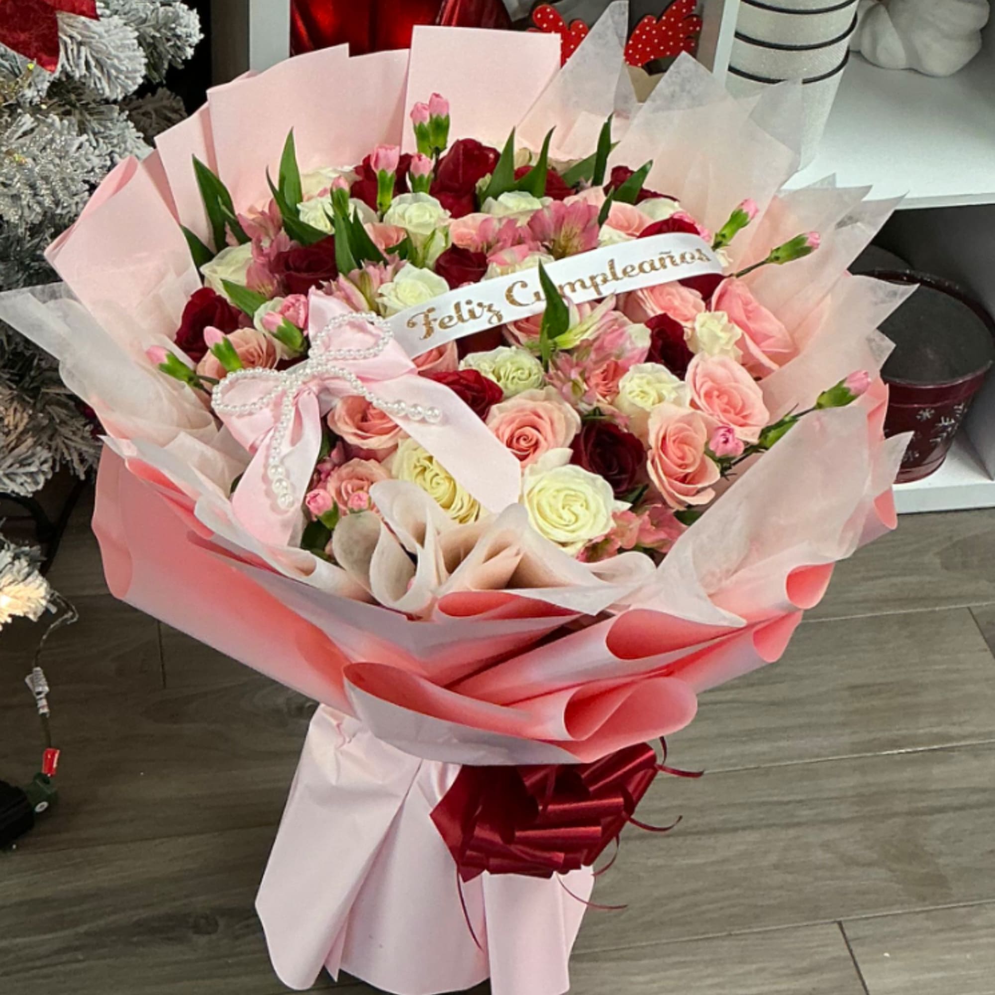 Large bouquet of pink and red roses with a "Feliz Cumpleaños" ribbon