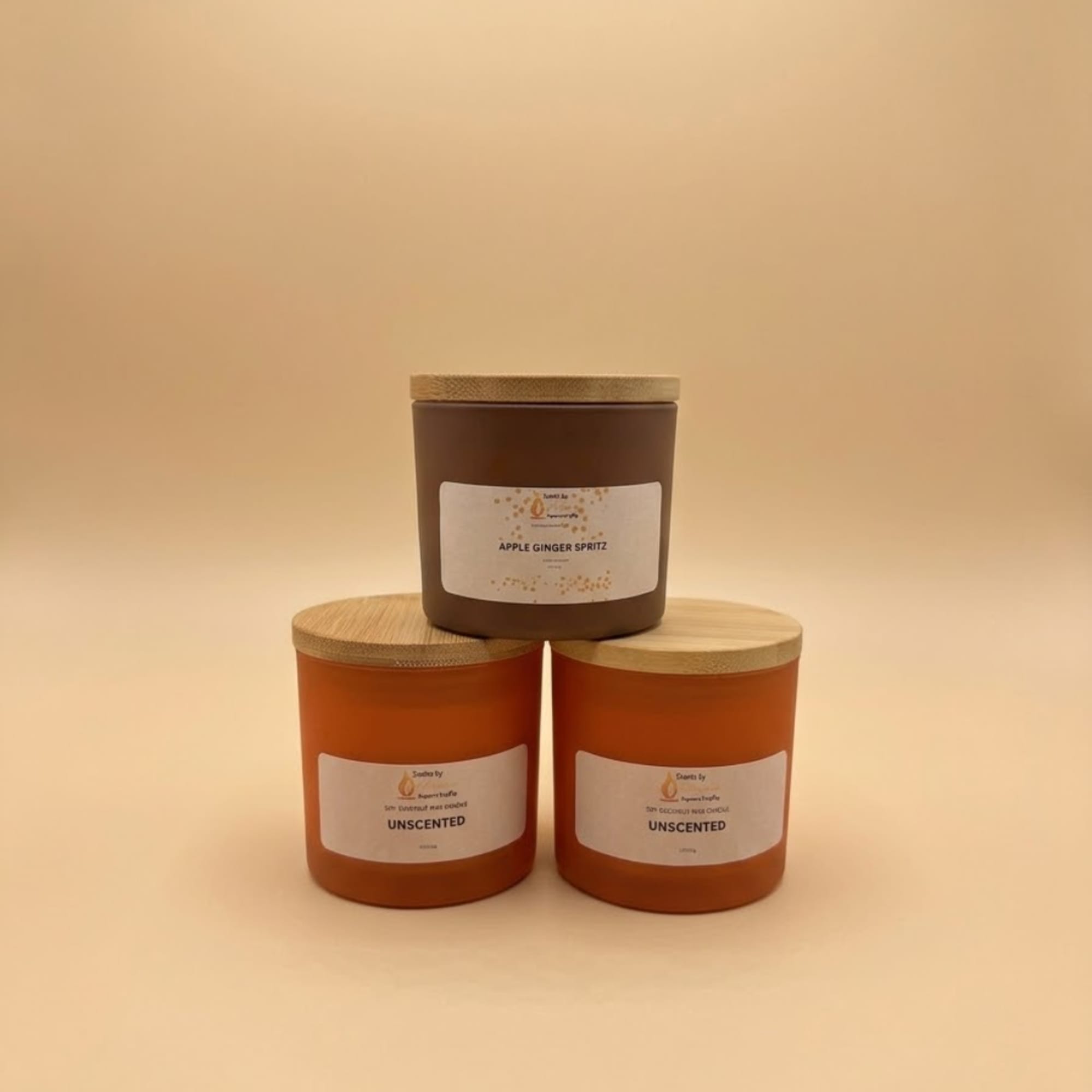 Three labeled candles with wooden lids on a neutral background