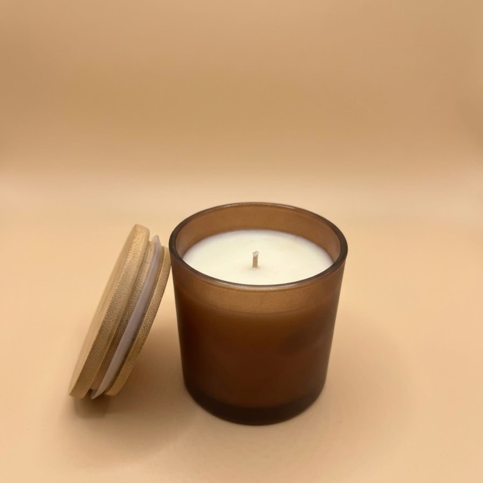 Brown glass candle with a lid beside it