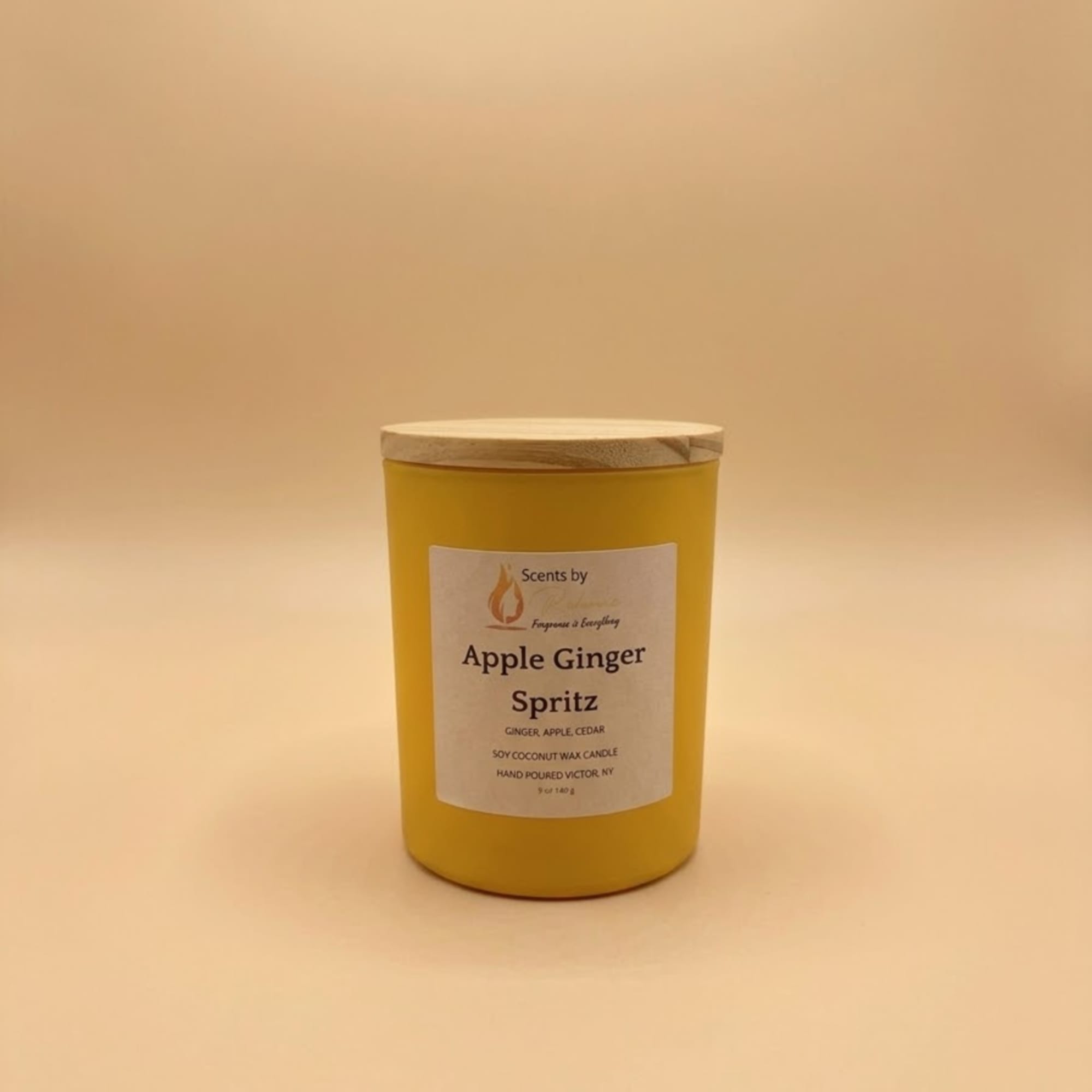Yellow candle jar with a wooden lid and labeled front