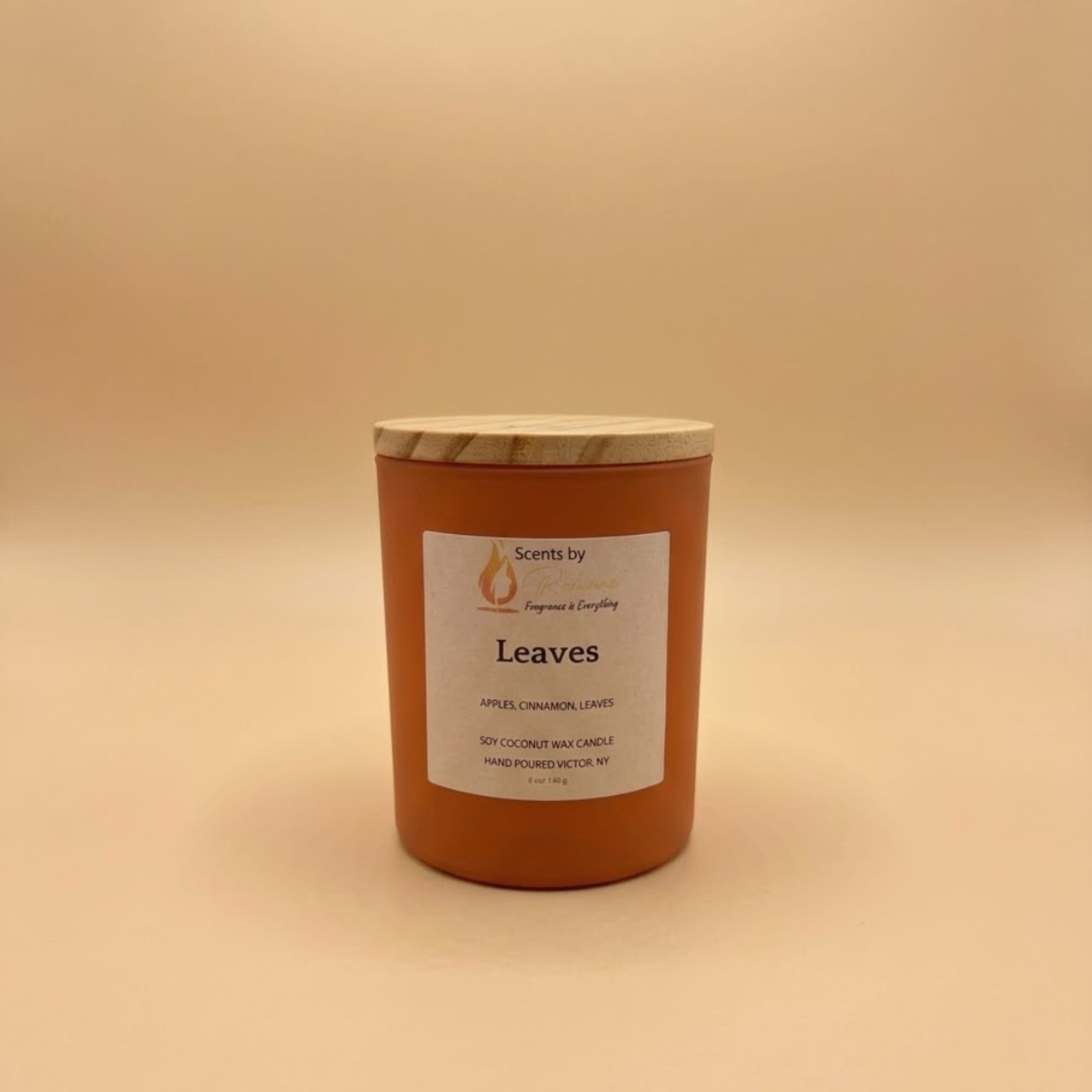 Orange scented candle in a jar with a wooden lid