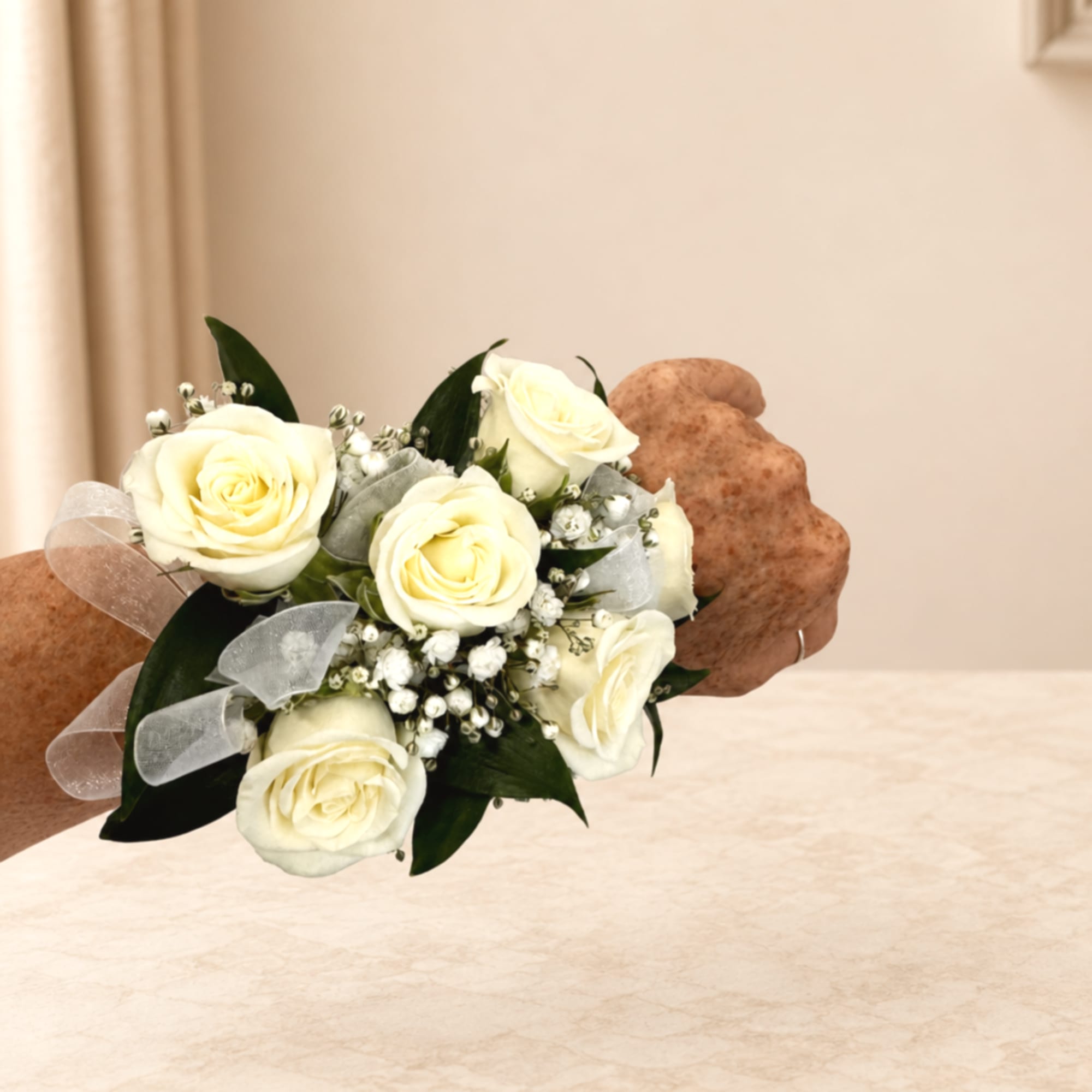 White rose wrist corsage with ribbon on a person's wrist