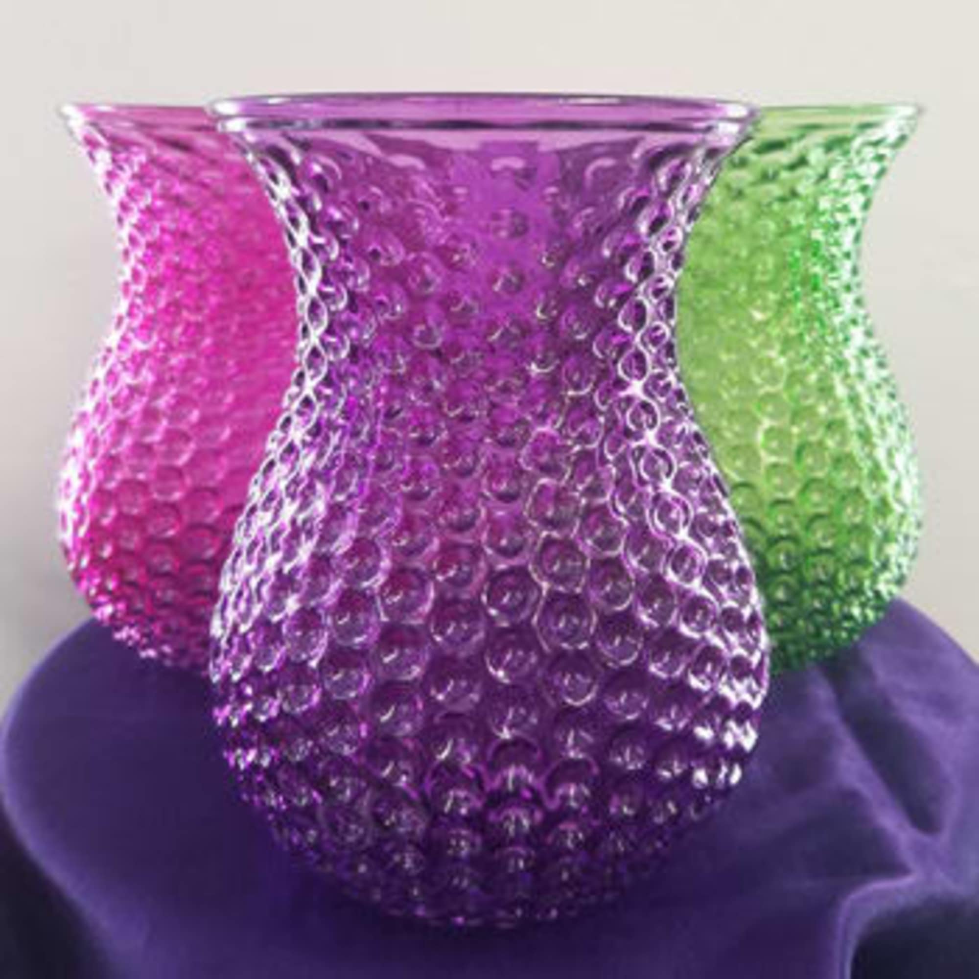 Three textured glass vases in pink, purple, and green