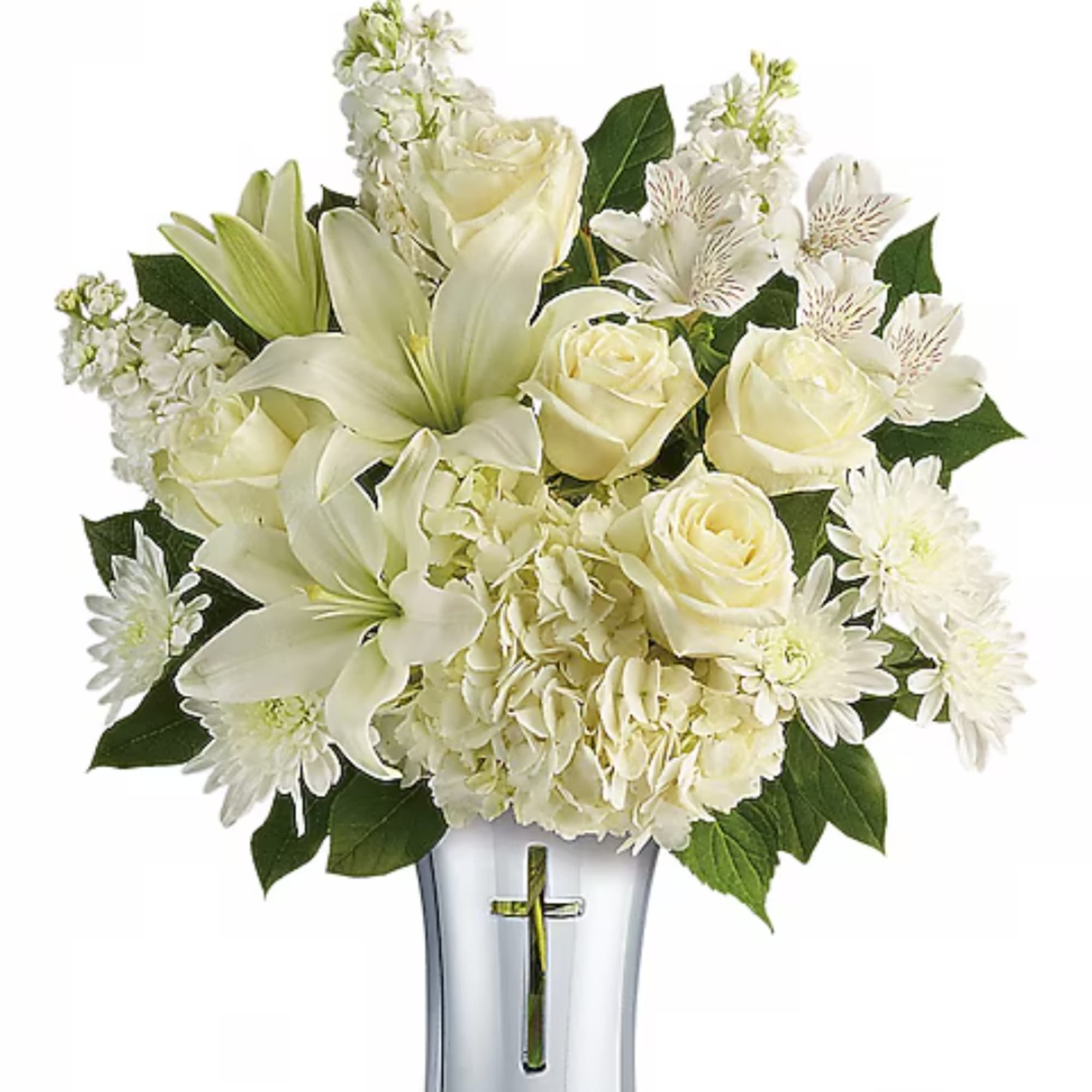White roses and lilies arranged in a clear vase with a cross accent