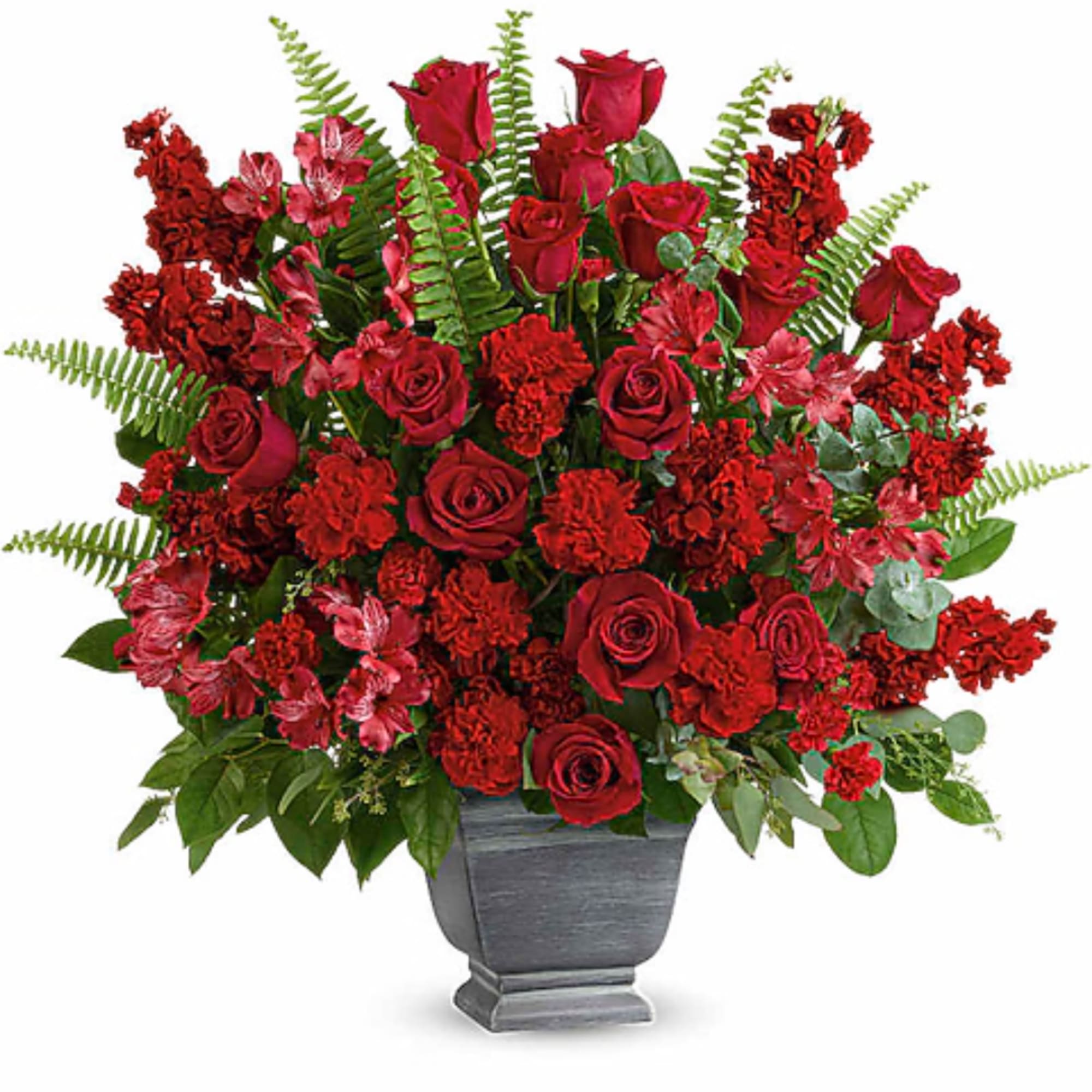 Red roses and carnations arranged in a gray urn vase