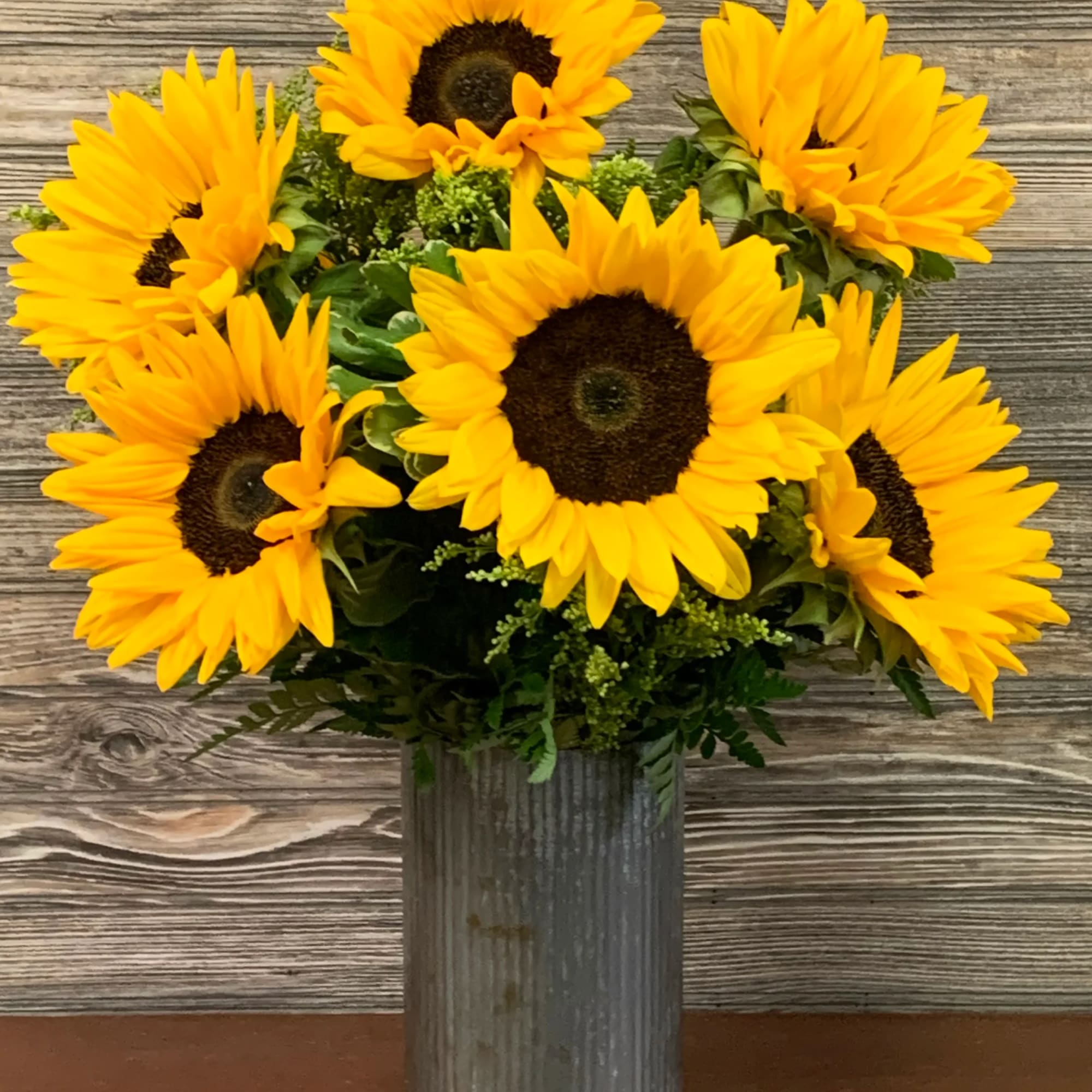 Sunflower arrangement in a tall metal vase