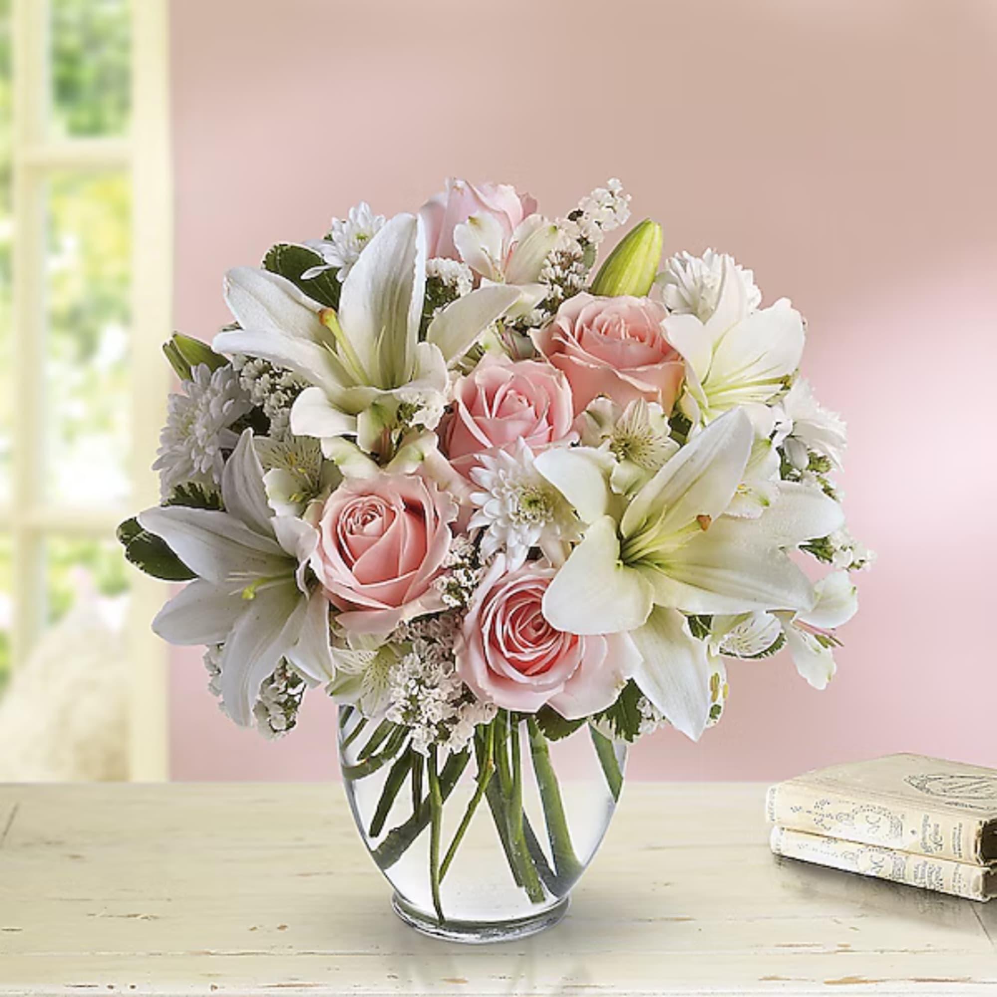 Pink roses and white lilies arranged in a clear glass vase, photo 2 of 2