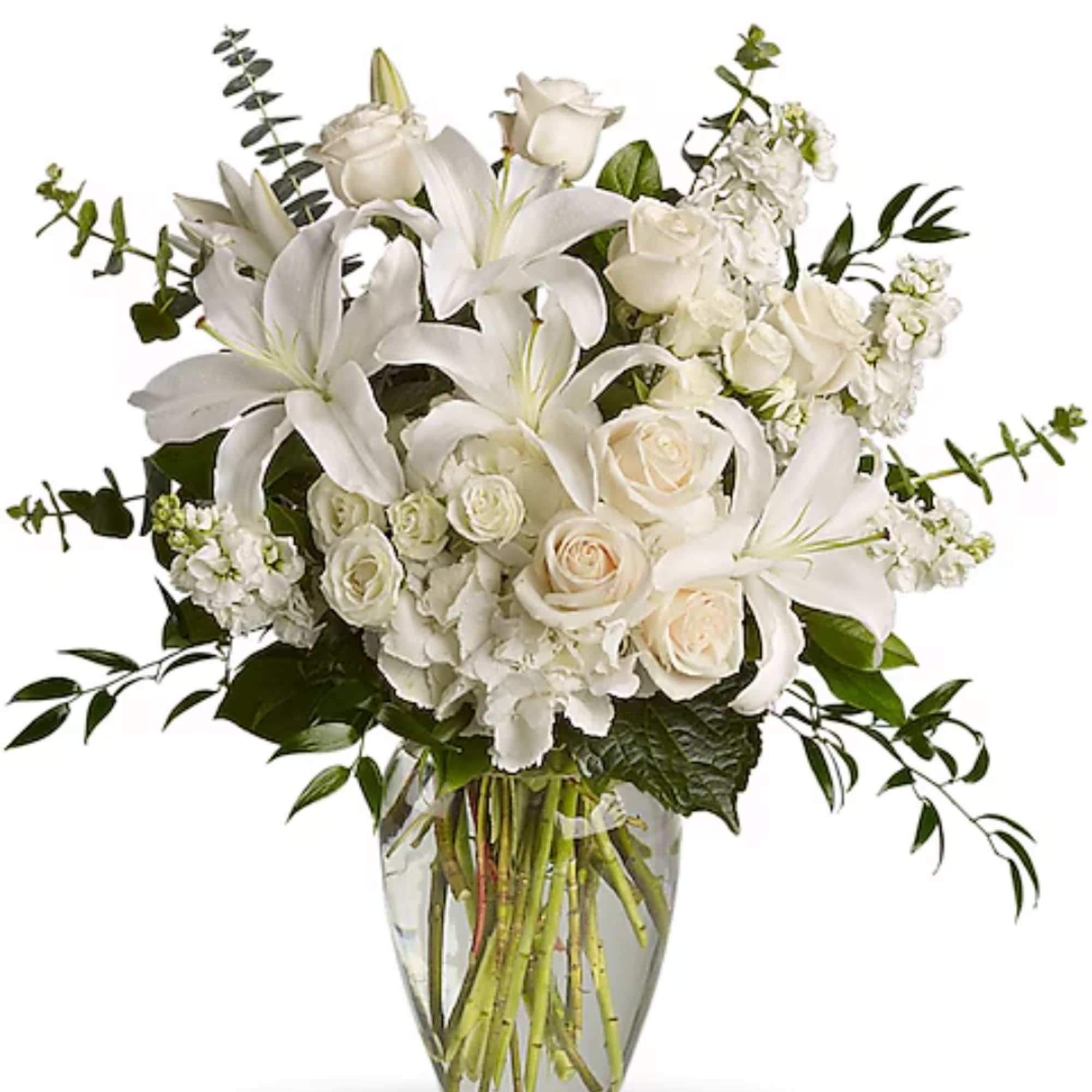 White lilies and roses arranged in a clear glass vase
