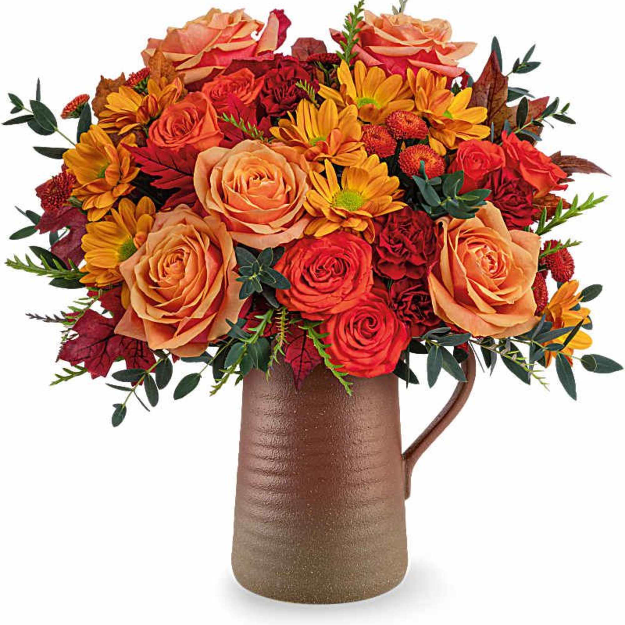 Orange and red flower arrangement in a brown pitcher vase