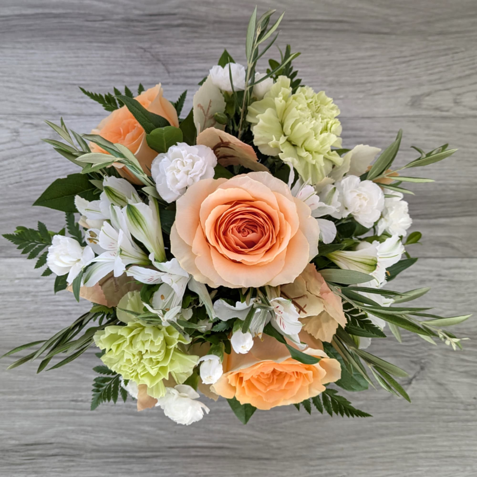 Peach roses and white flowers arranged in a bouquet