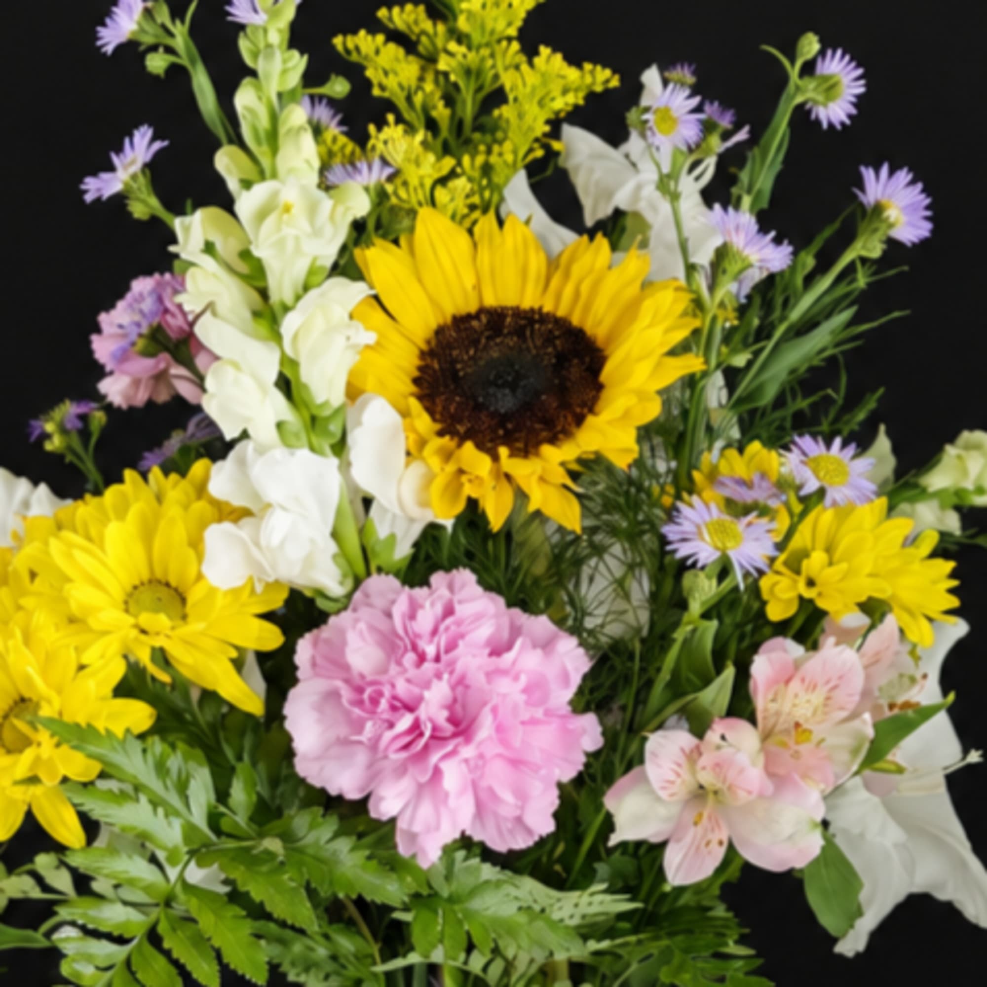 Mixed bouquet with sunflowers, white snapdragons, pink carnations, and small purple daisies
