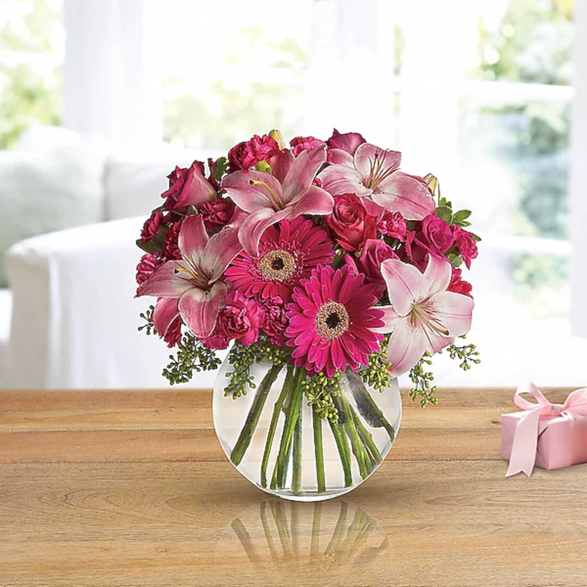 Pink lilies, gerbera daisies, and roses in a clear glass vase, photo 2 of 2