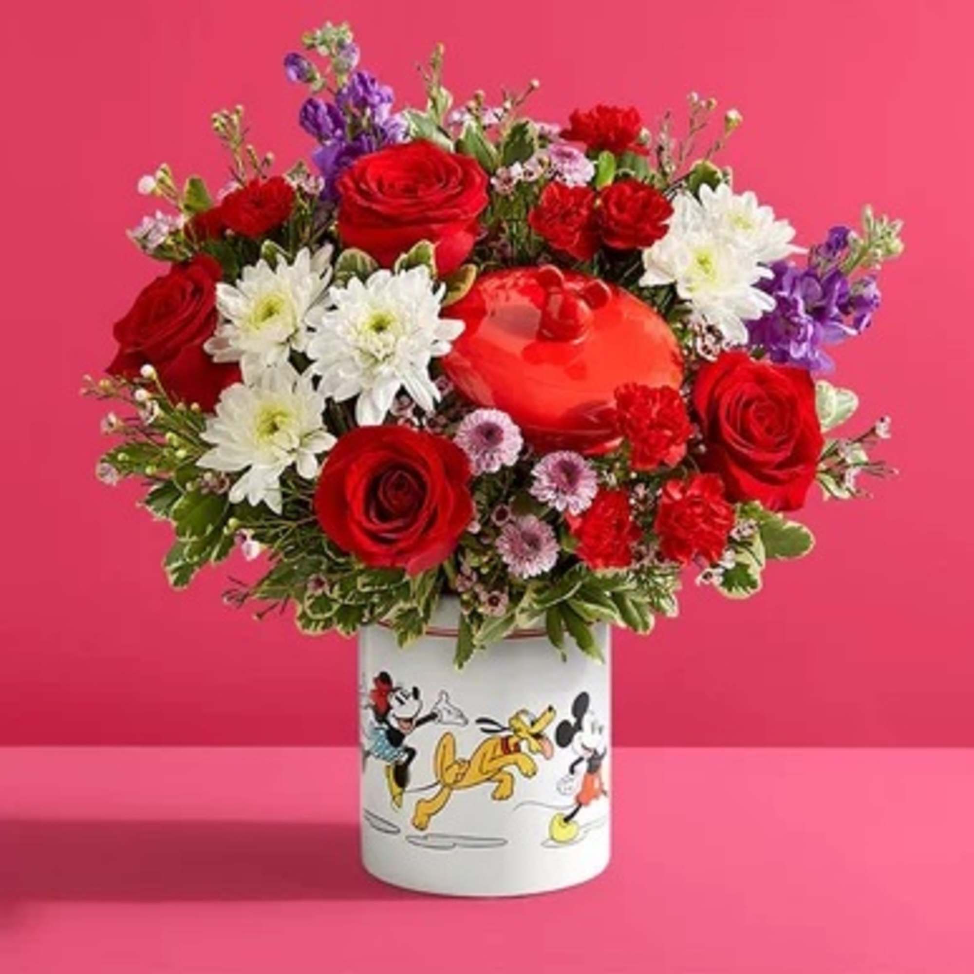 Red roses and white daisies in a Mickey Mouse vase
