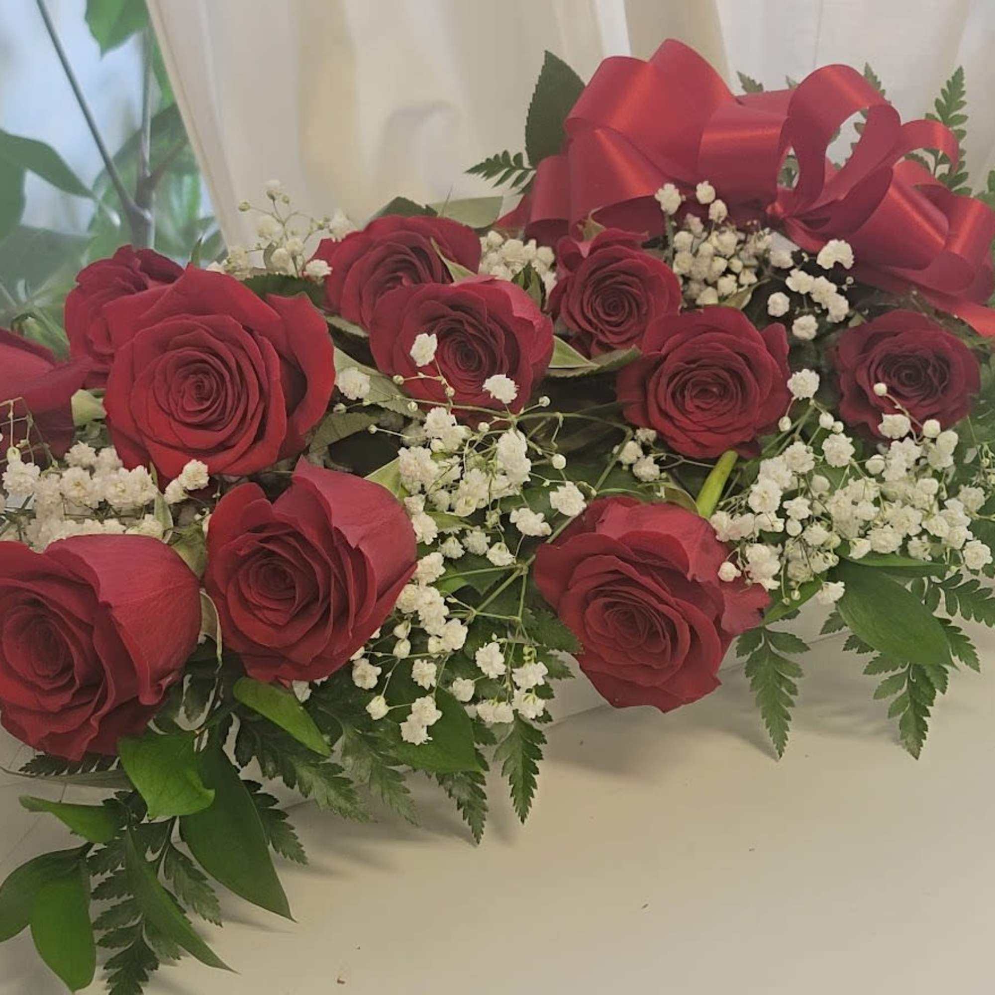 Red roses with baby's breath and a red ribbon