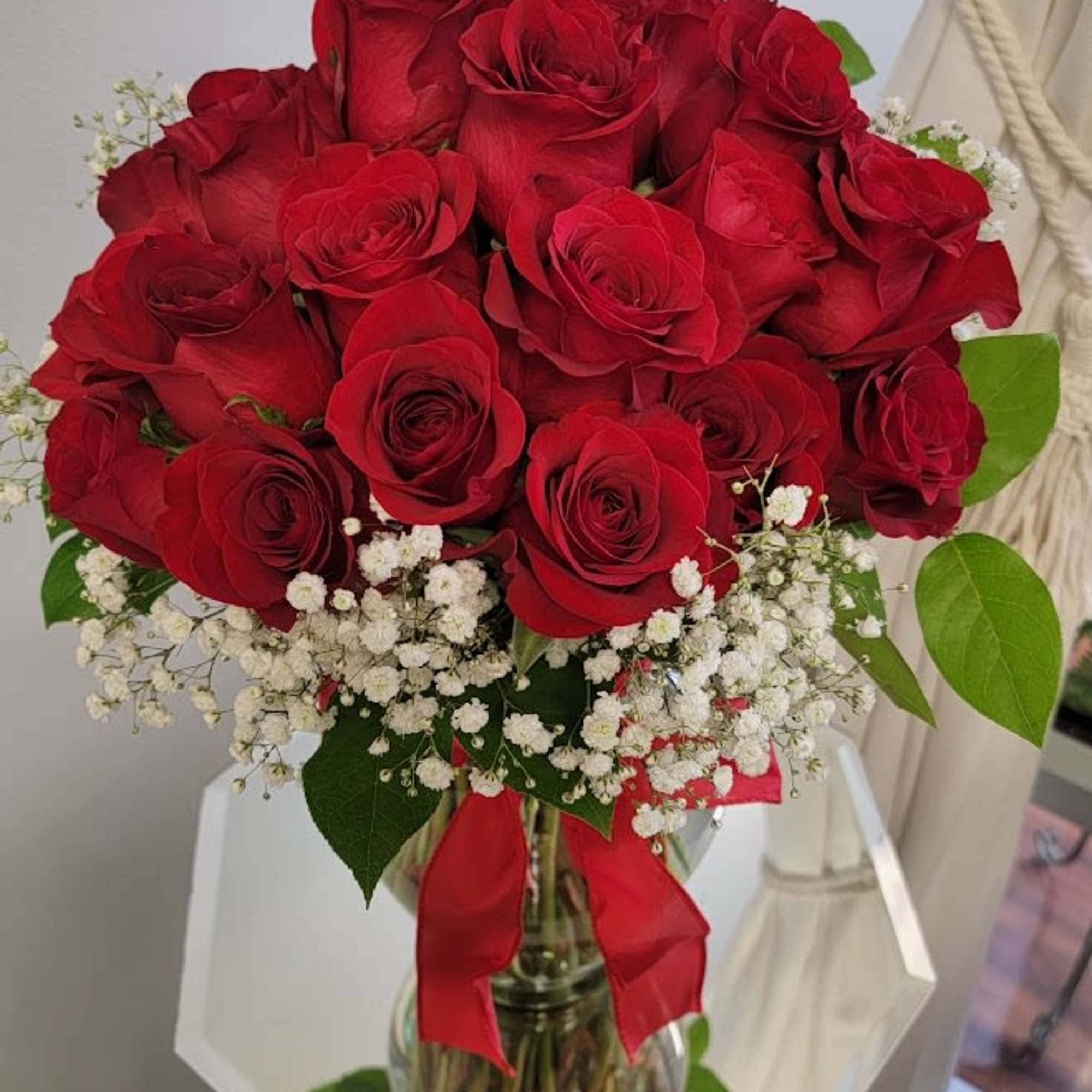 Bouquet of red roses with white baby's breath in a glass vase