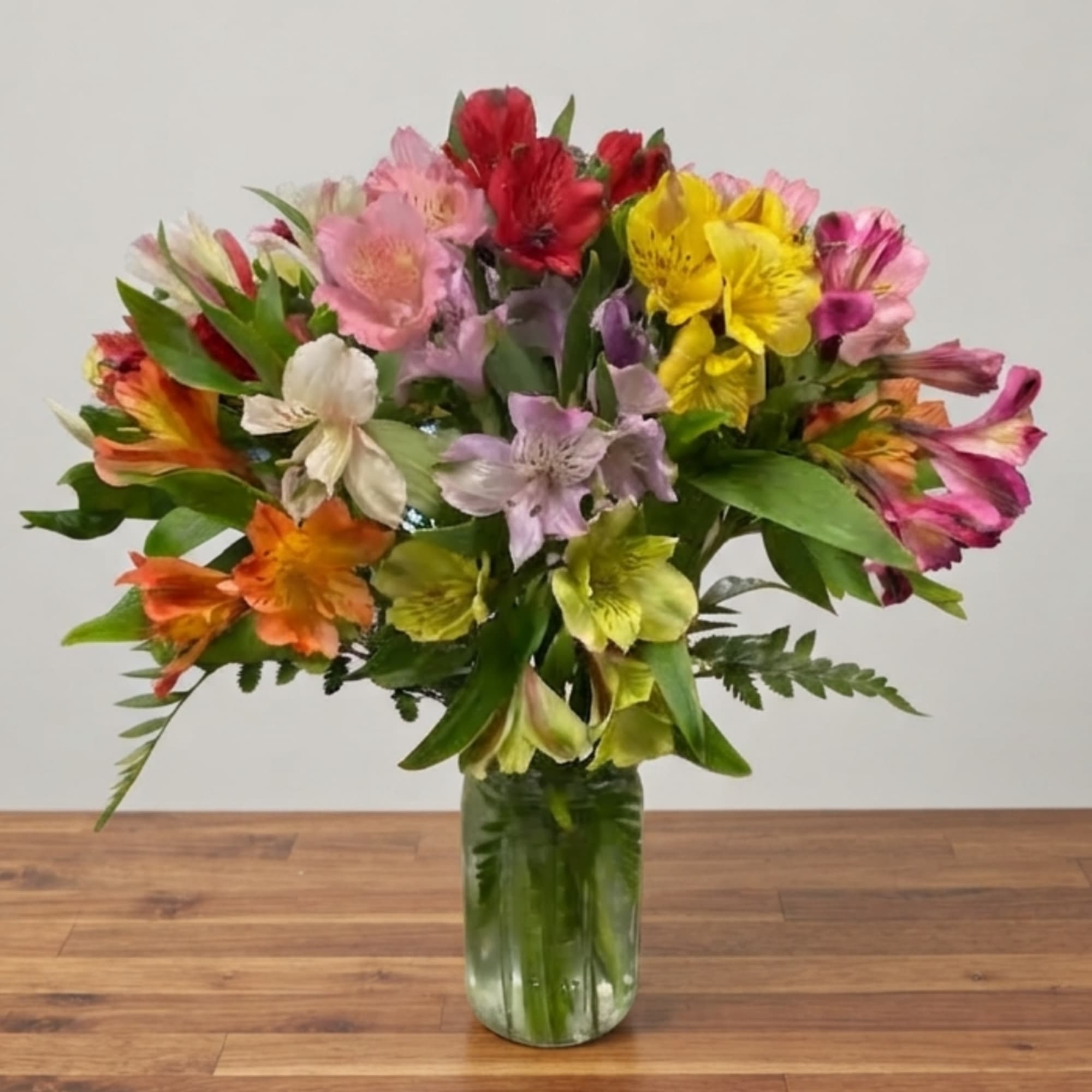 Colorful bouquet of alstroemeria in a clear glass vase, photo 2 of 4