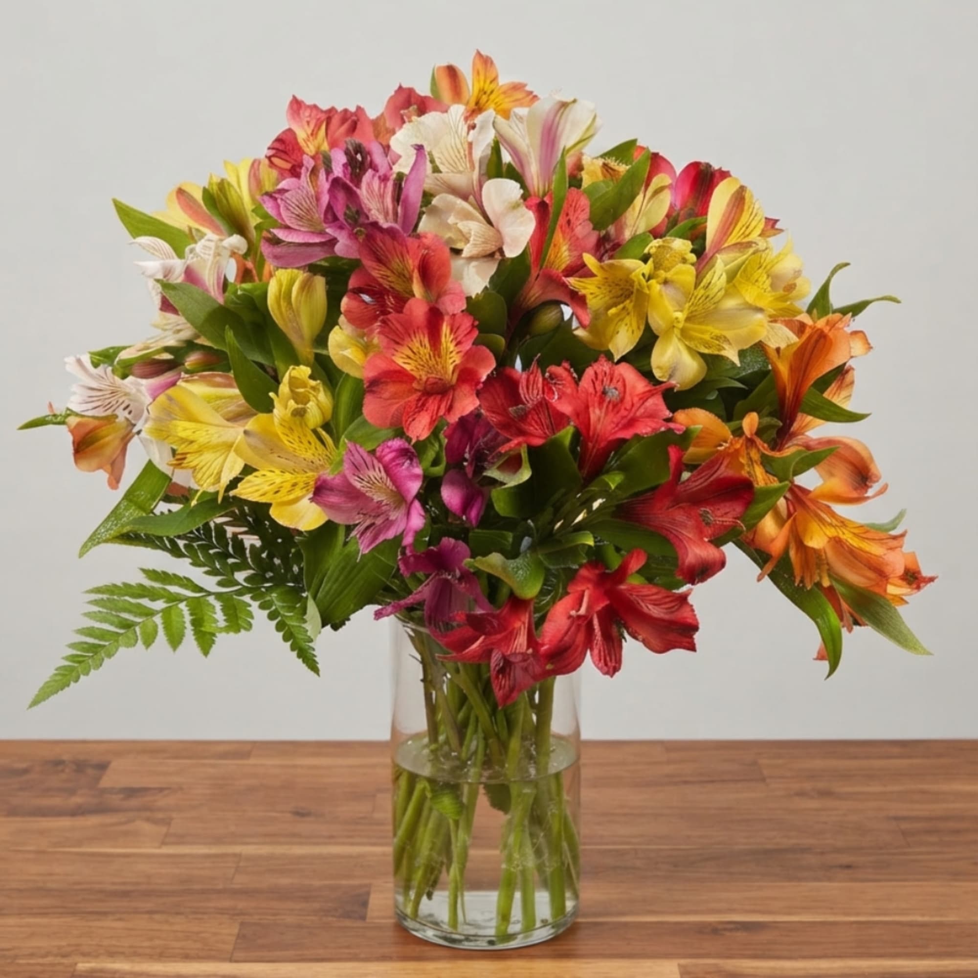 Colorful bouquet of alstroemeria in a clear glass vase, photo 3 of 4