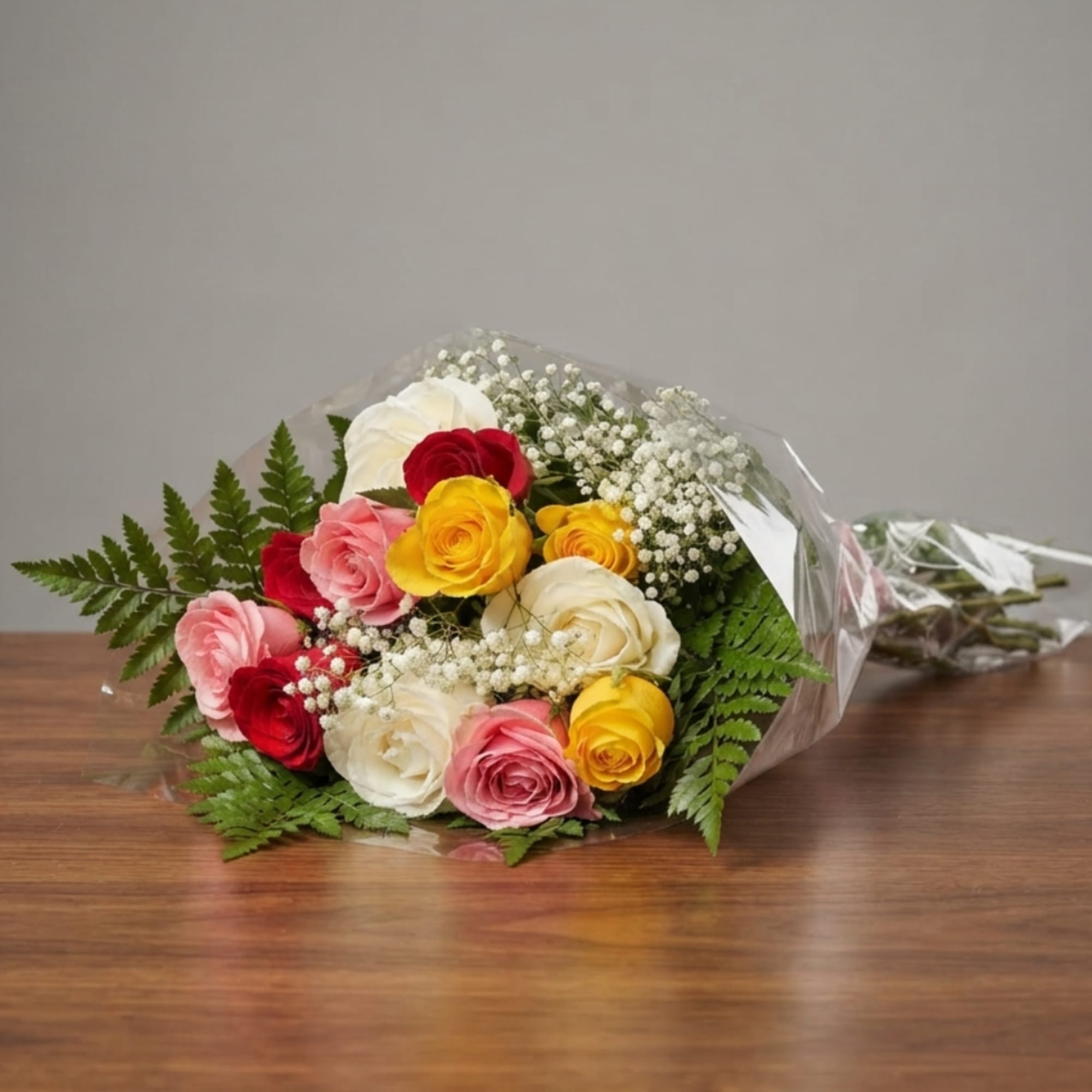 Bouquet of multicolored roses wrapped in clear plastic