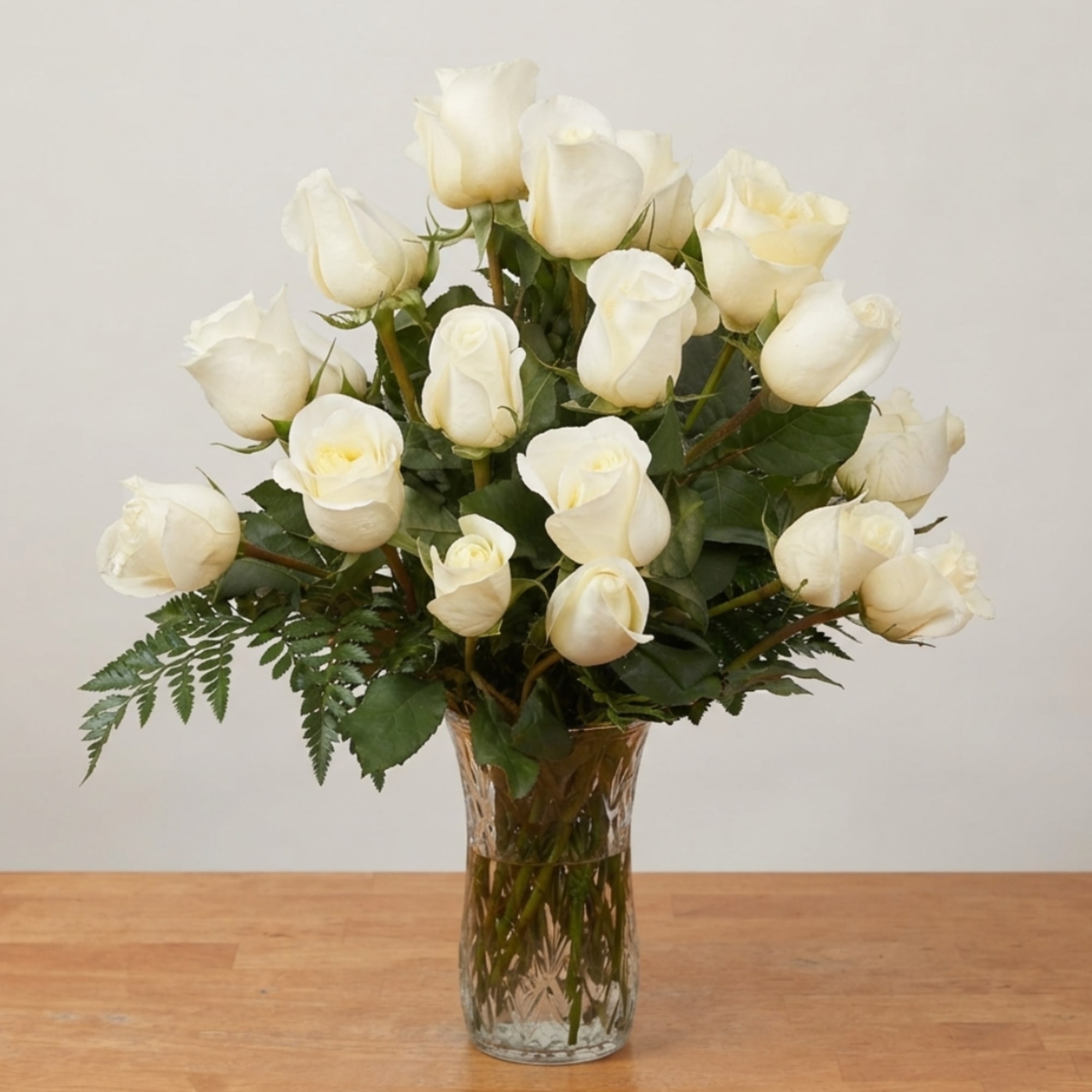 White roses arranged in a clear glass vase