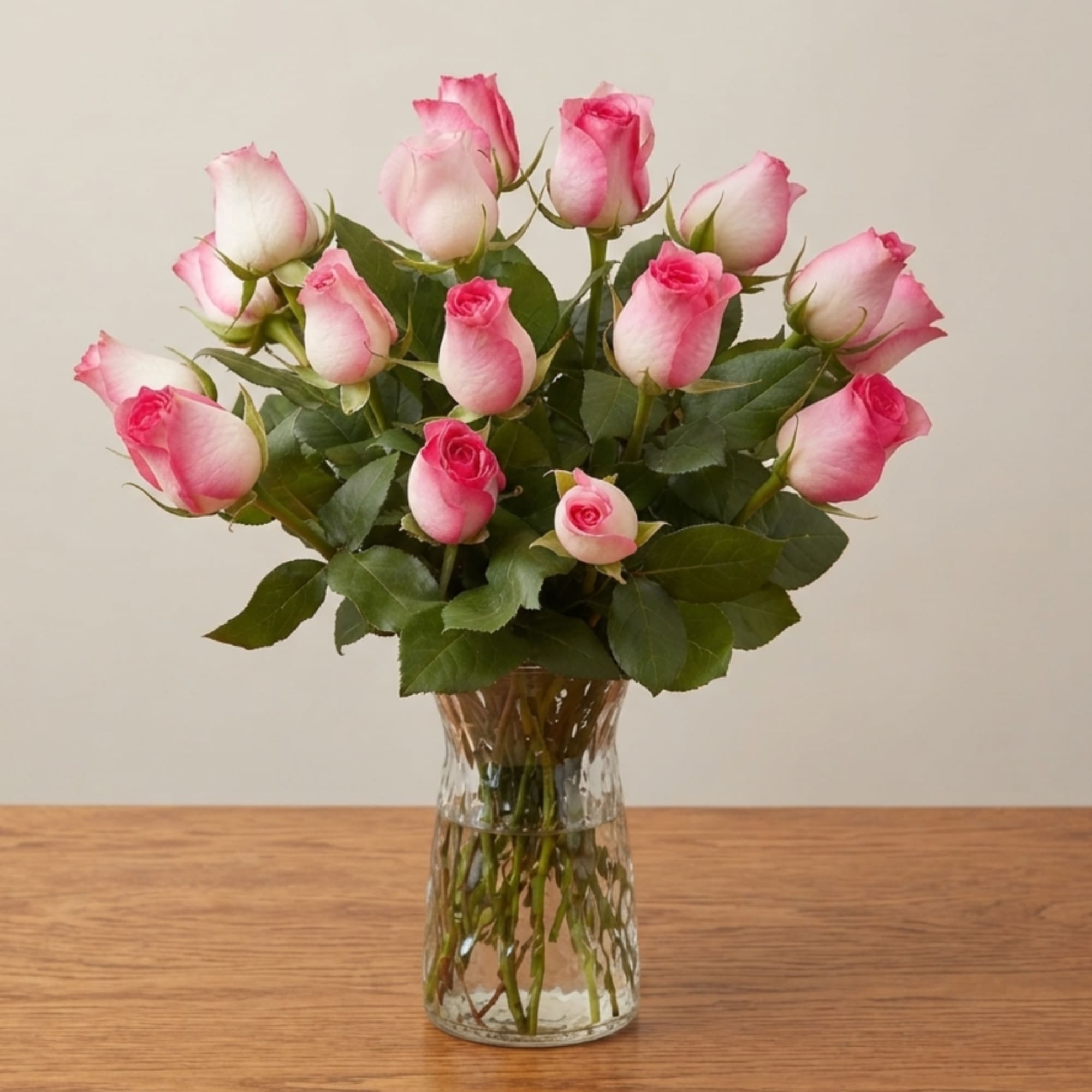 Pink and white roses arranged in a clear glass vase