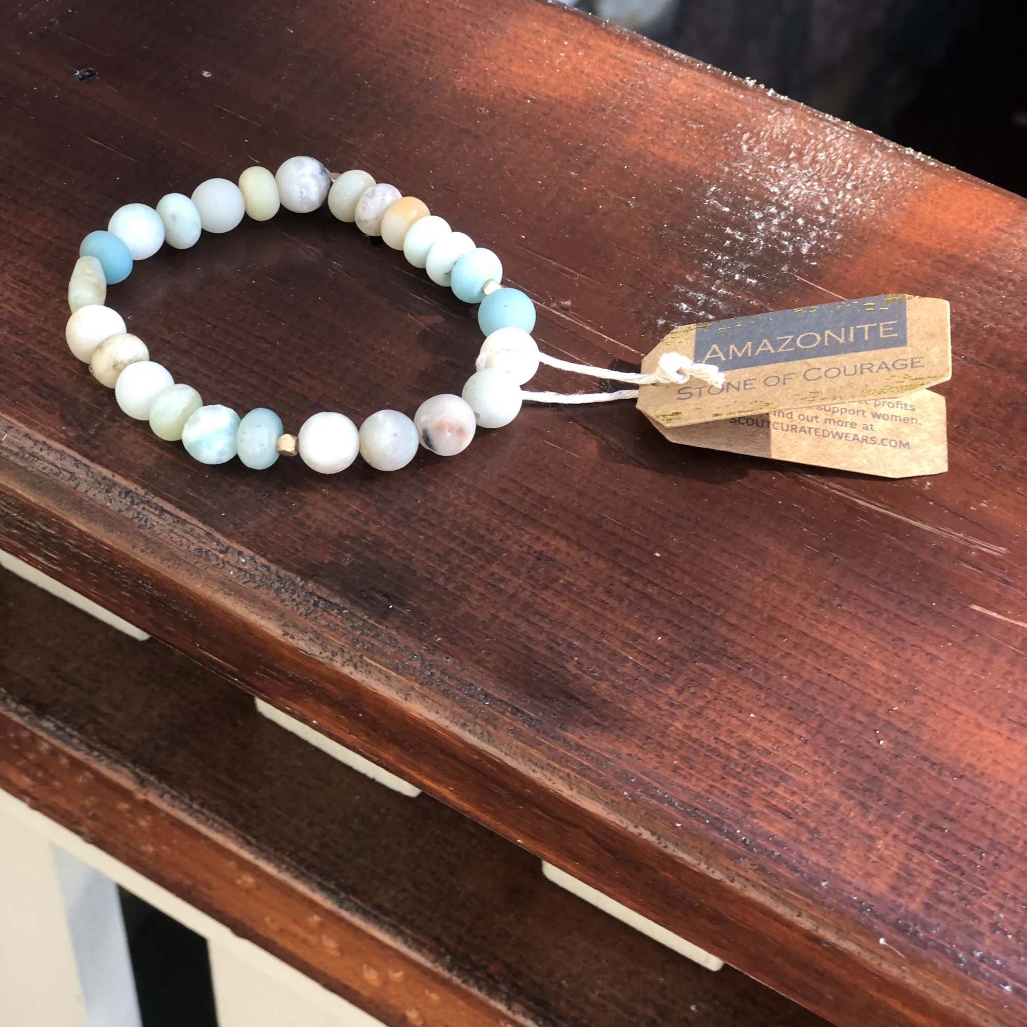 Beaded bracelet with pale blue and white stones on a wooden surface
