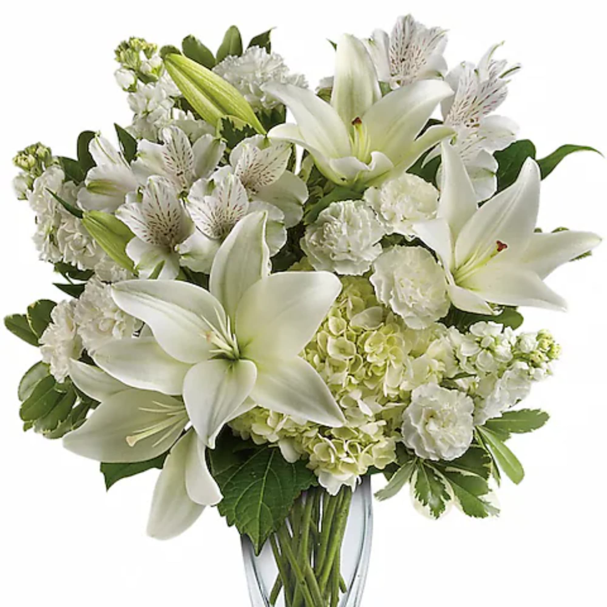White lilies and mixed white flowers in a clear glass vase