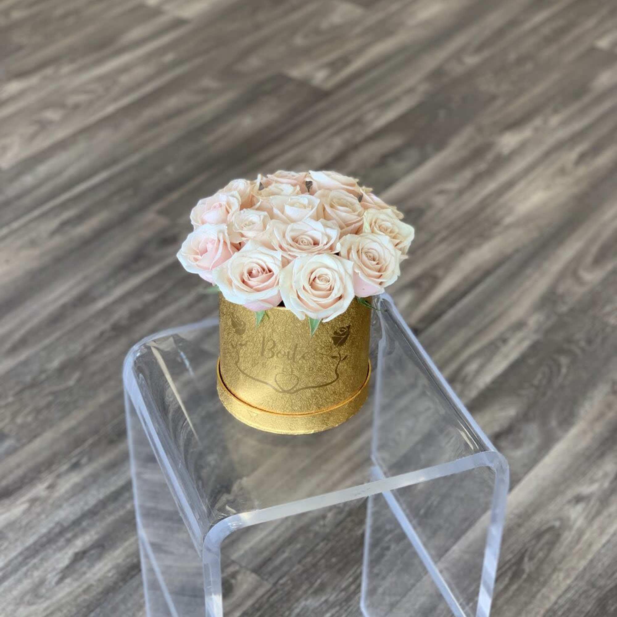 Small bouquet of pale pink roses in a gold round box