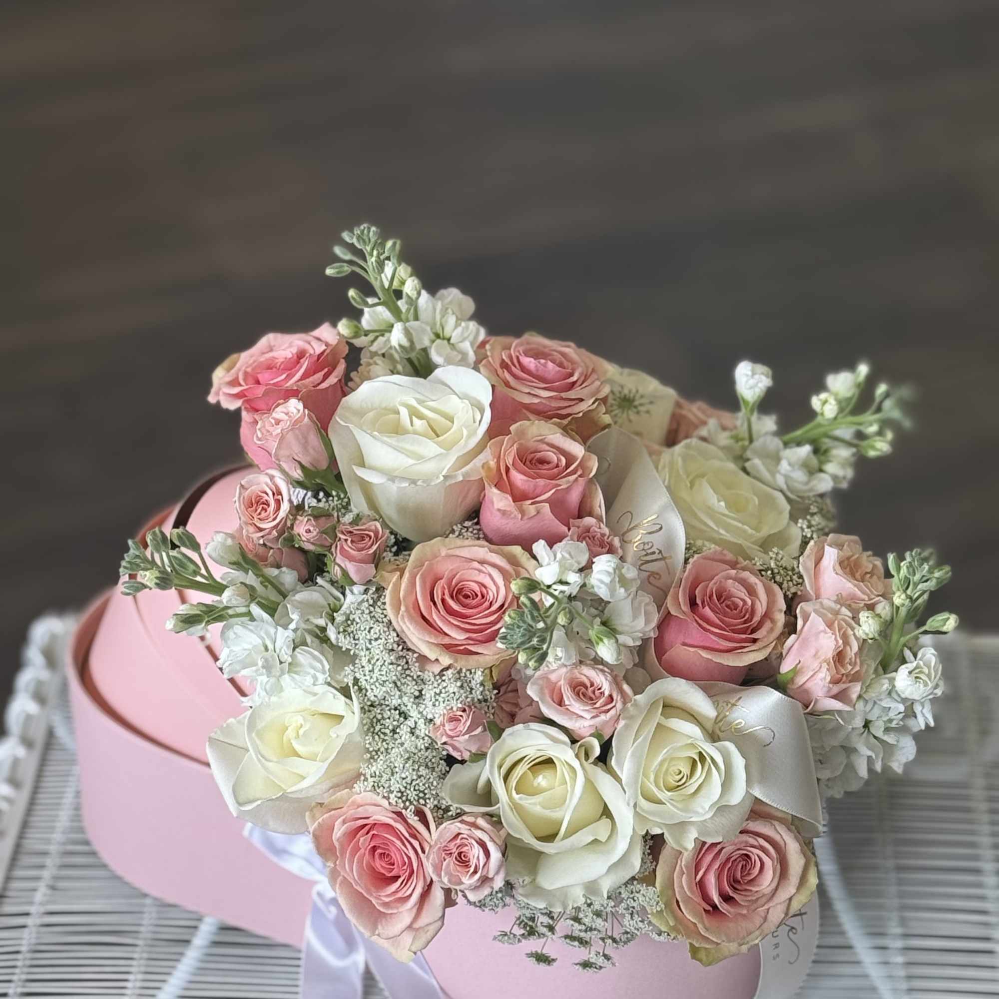Pink and white rose bouquet in a round pink box with ribbon