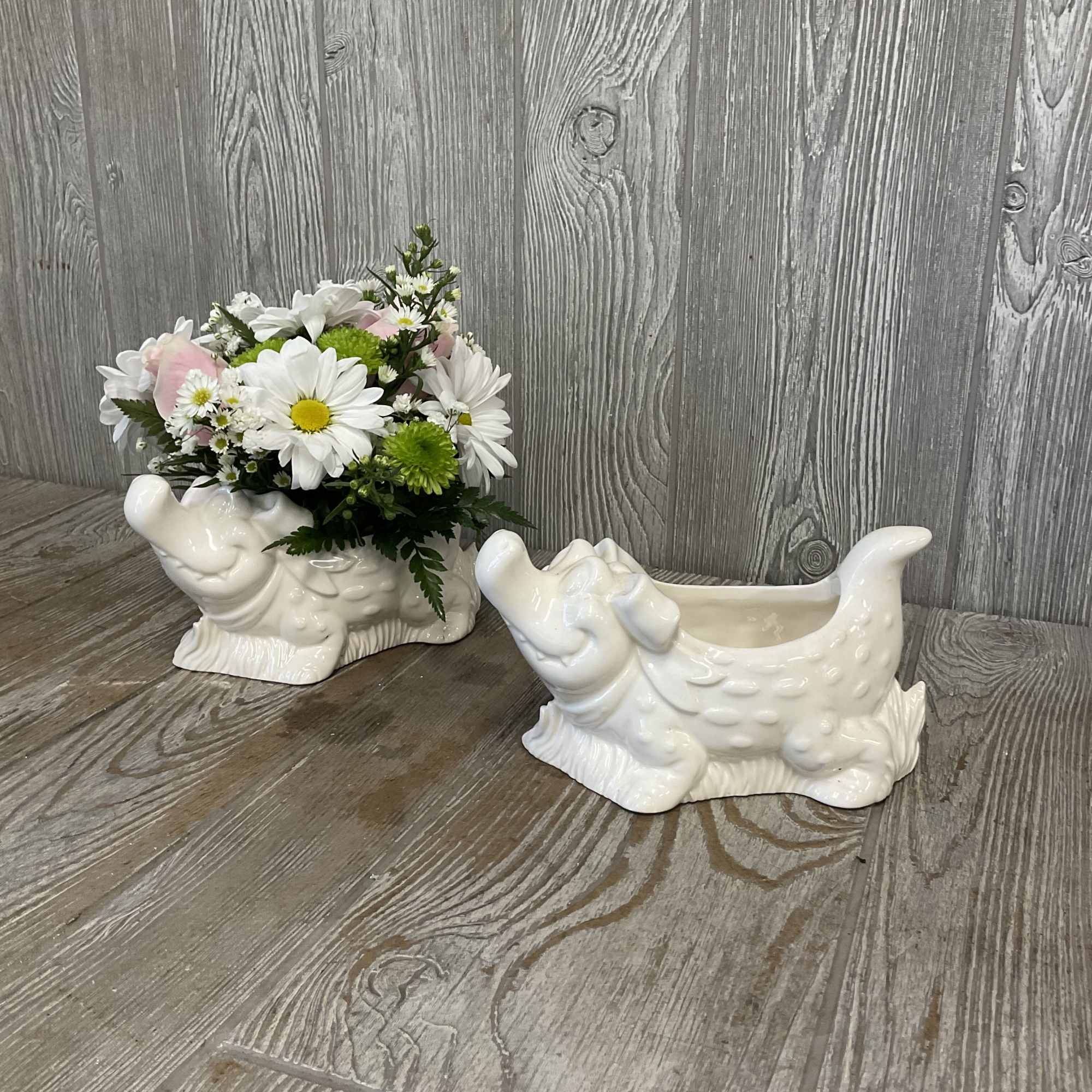 White and pink daisy bouquet in a ceramic dog-shaped planter