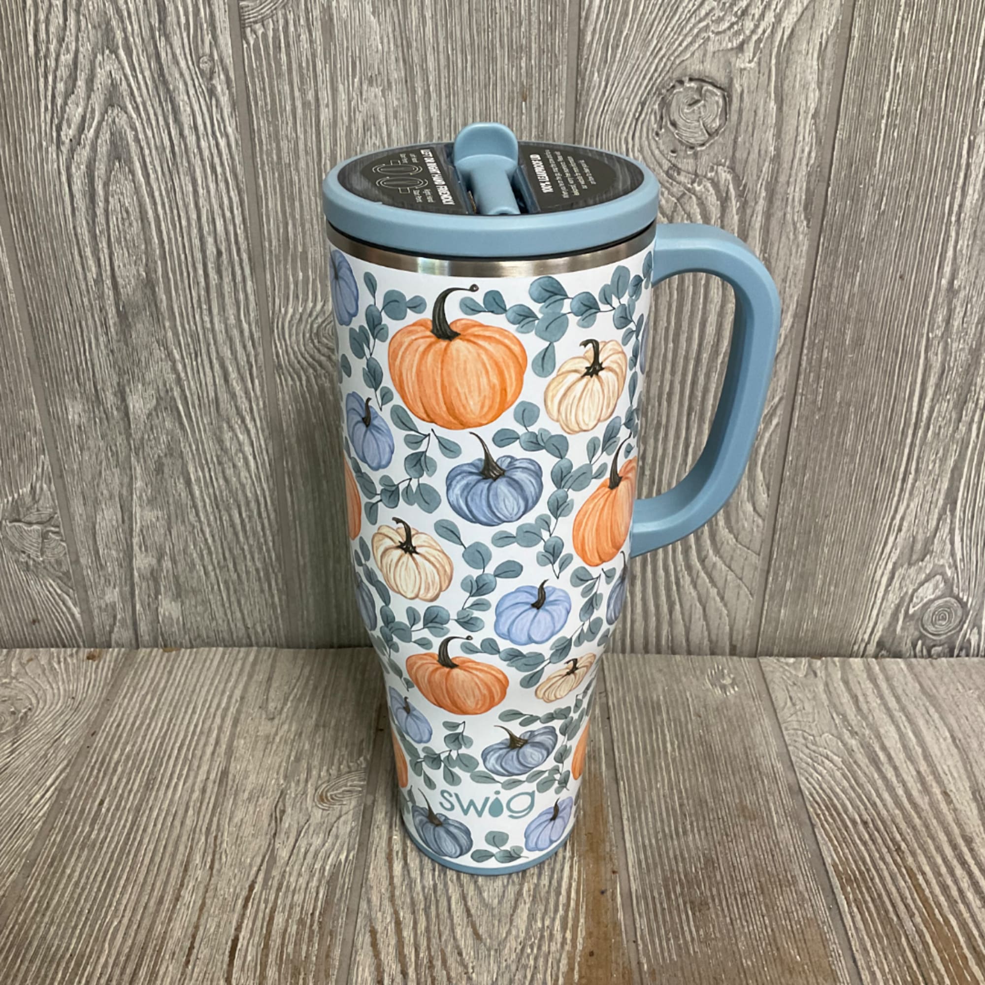 Blue handled travel mug with pumpkin pattern and lid