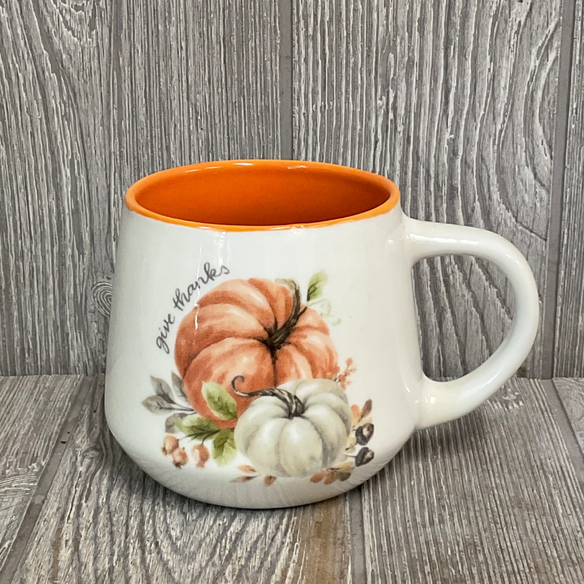 Ceramic mug with pumpkin artwork and orange interior