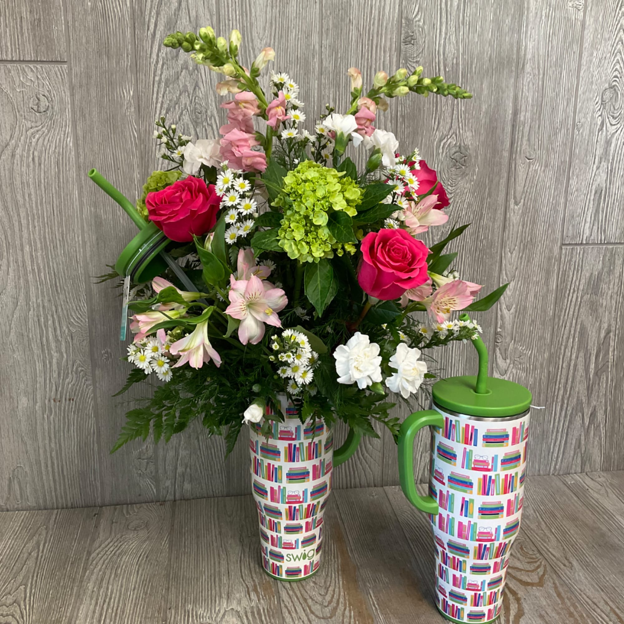 Mixed bouquet with pink roses, white daisies, and green hydrangea in a patterned mug vase