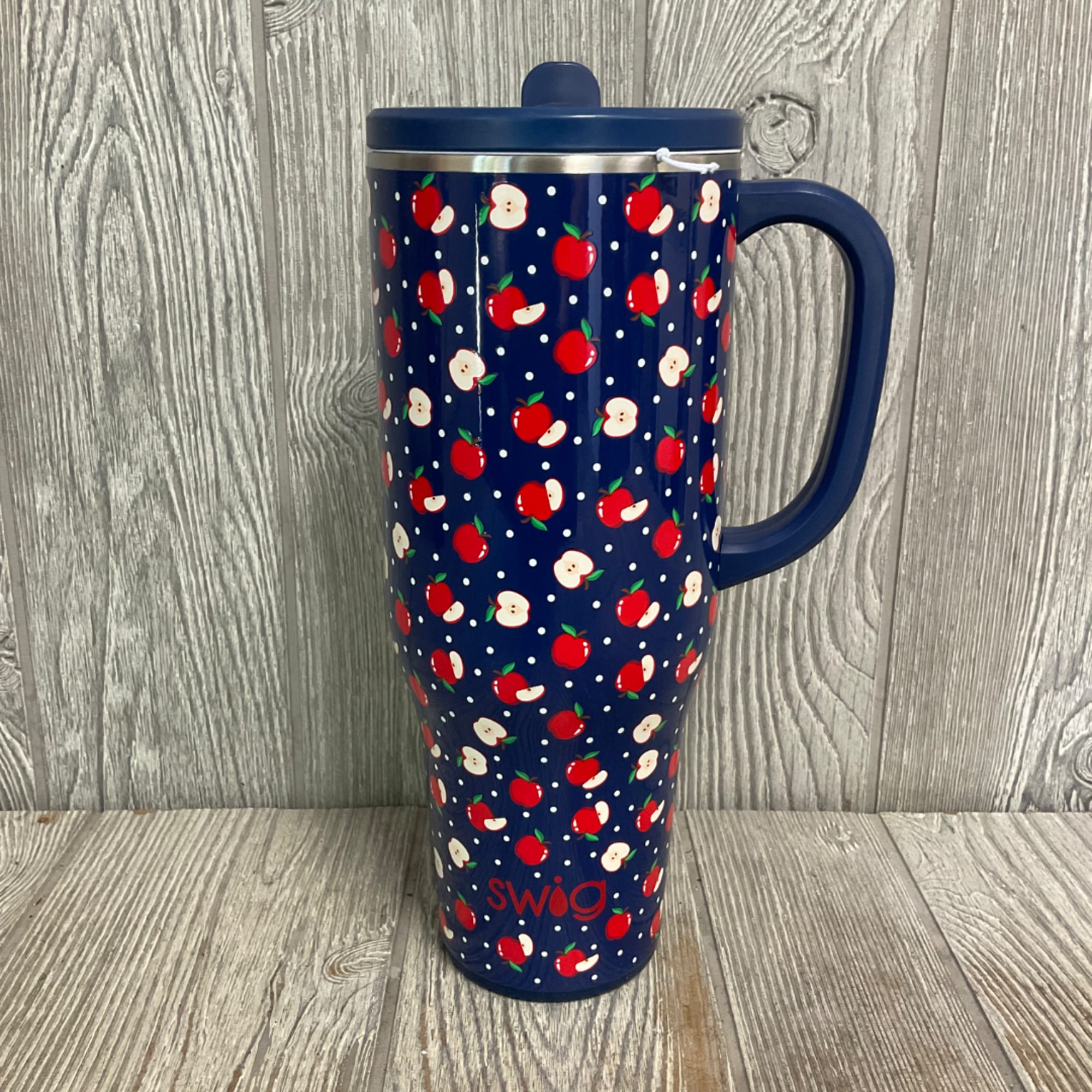 Blue insulated travel mug with an apple pattern and handle