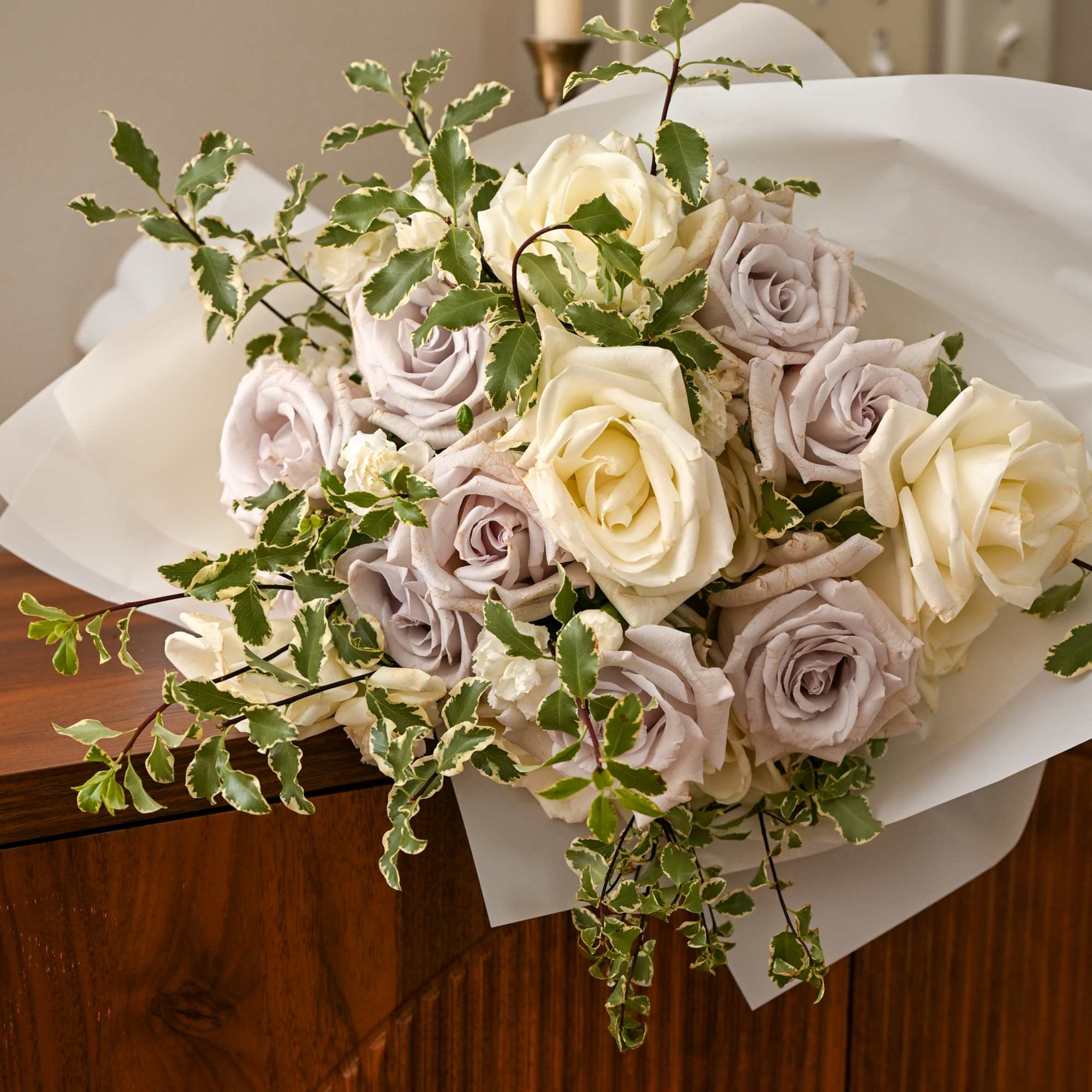 Bouquet of cream and lavender roses with variegated greenery