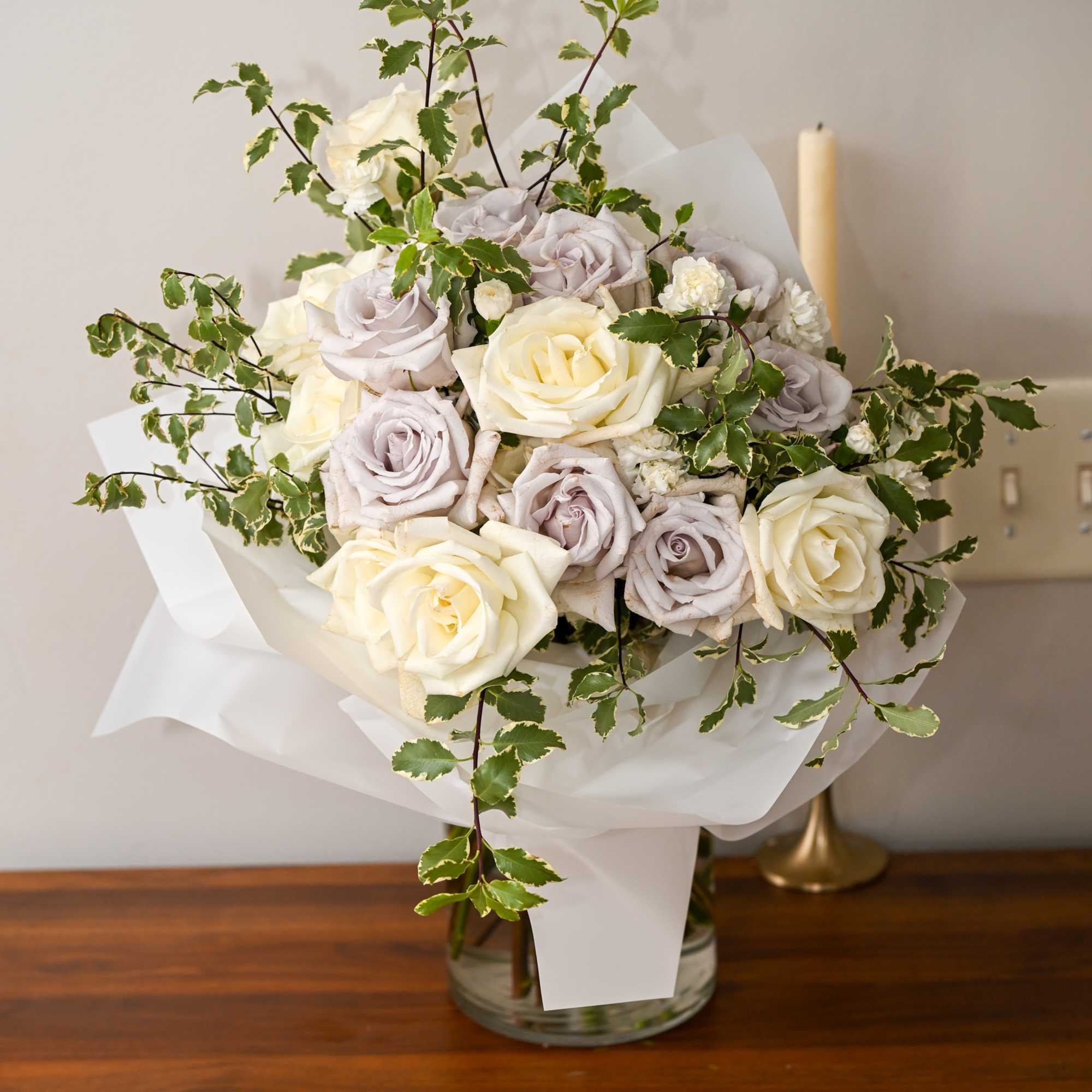 Bouquet of cream and pale lavender roses in white wrap