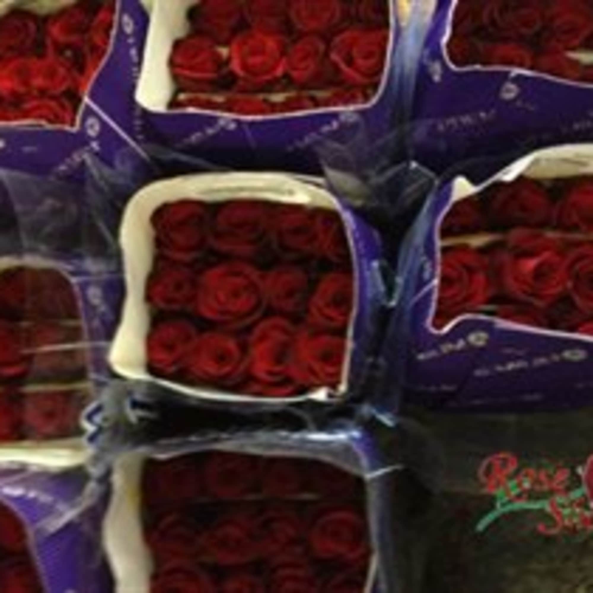 Boxes of red roses wrapped in purple packaging