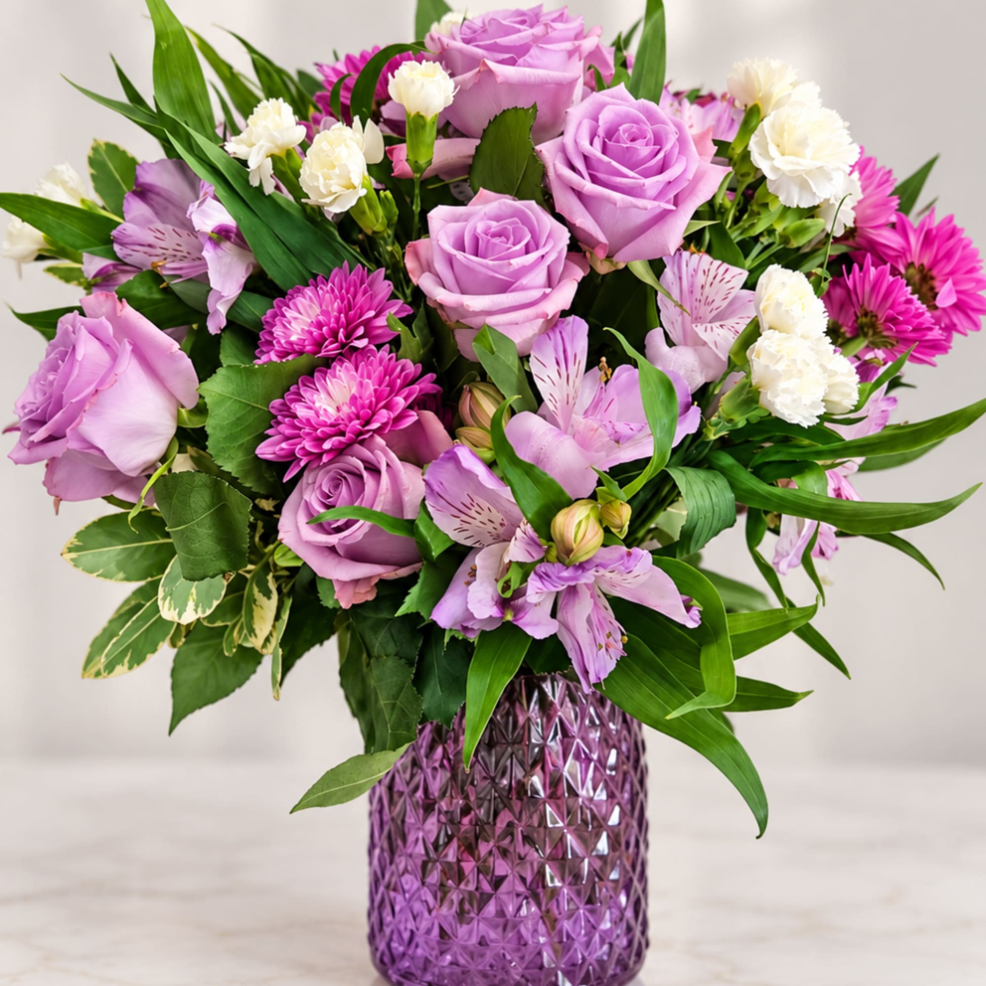 Lavender roses and pink flowers in a purple glass vase, photo 2 of 4