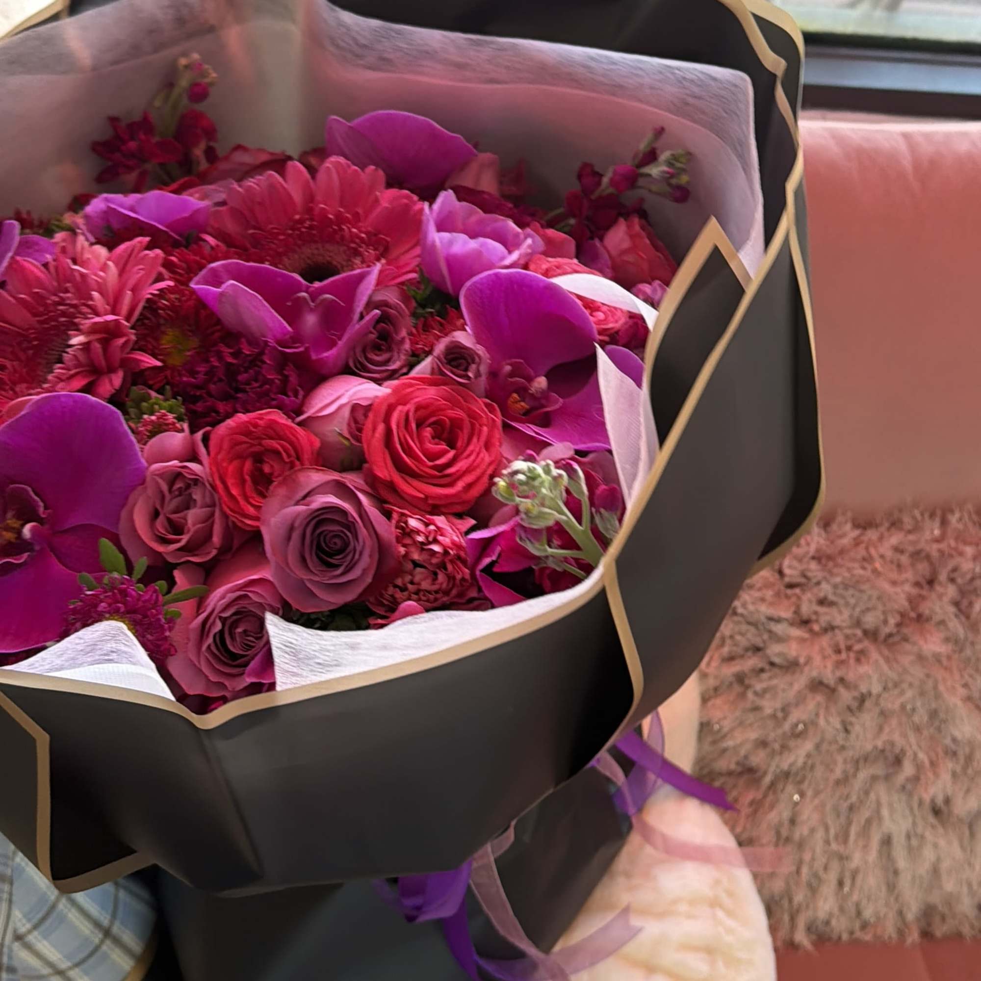 Bouquet of pink and purple roses with orchids and gerbera daisies