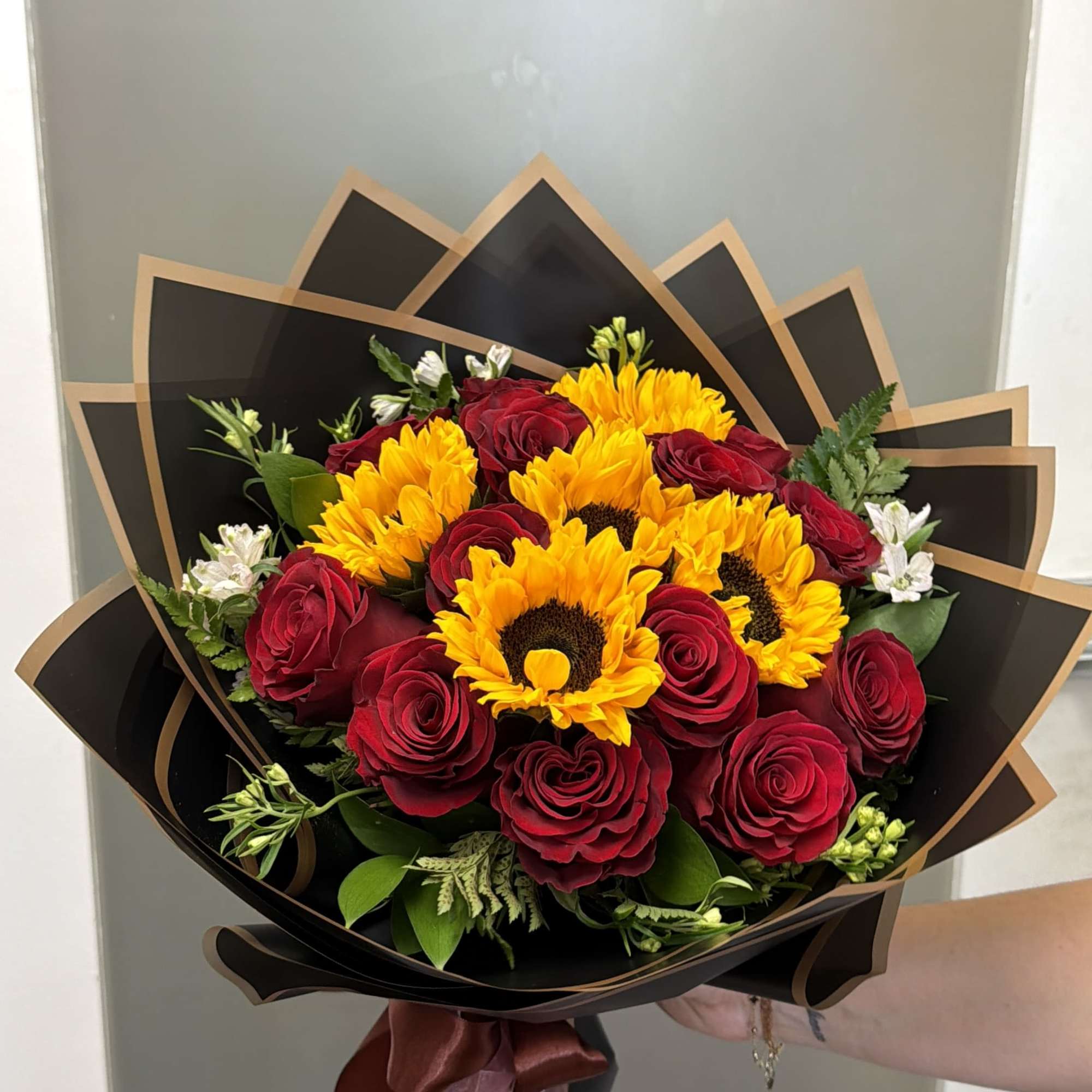 Bouquet of red roses and yellow sunflowers wrapped in black paper, photo 2 of 3