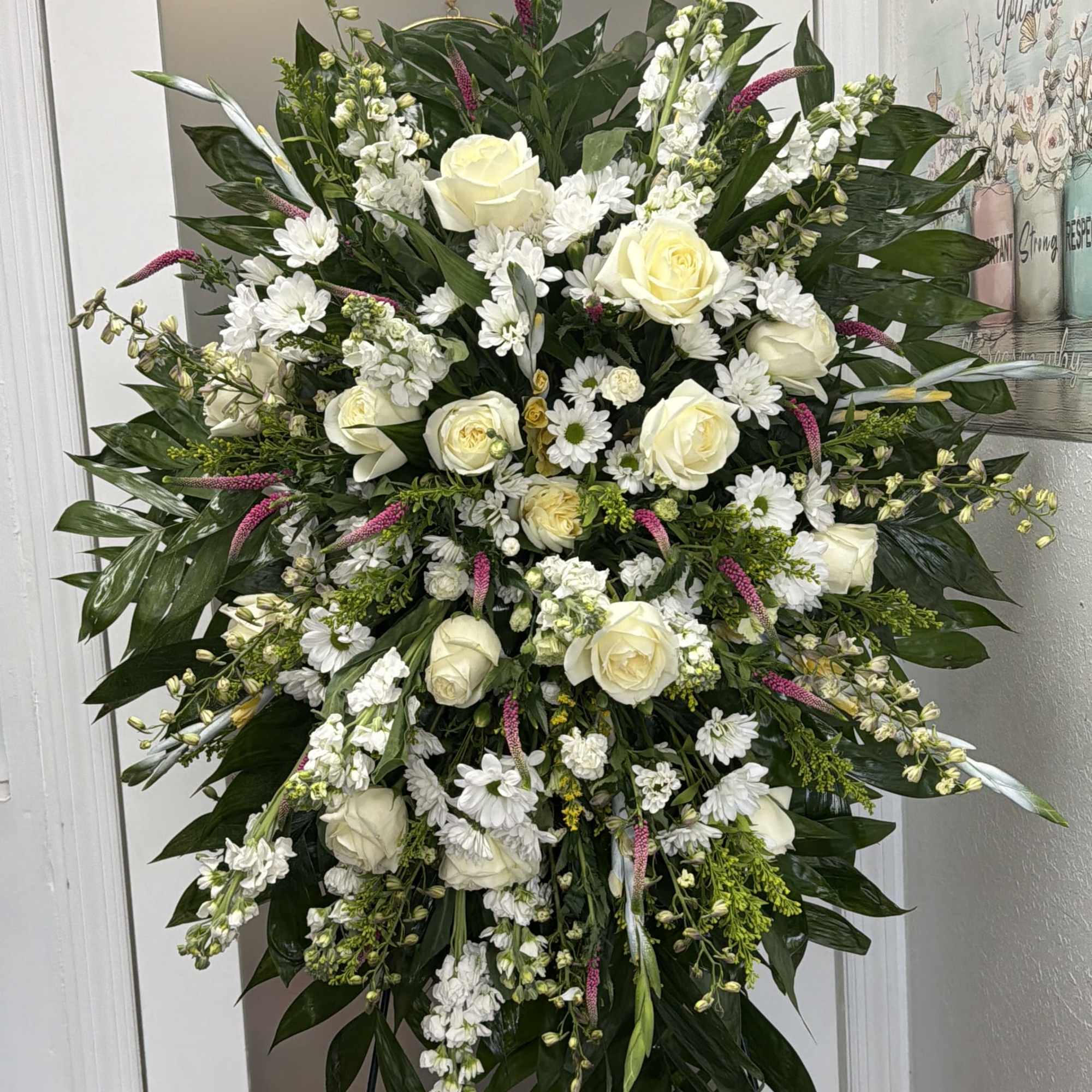 Large standing spray of white roses and daisies with dark foliage