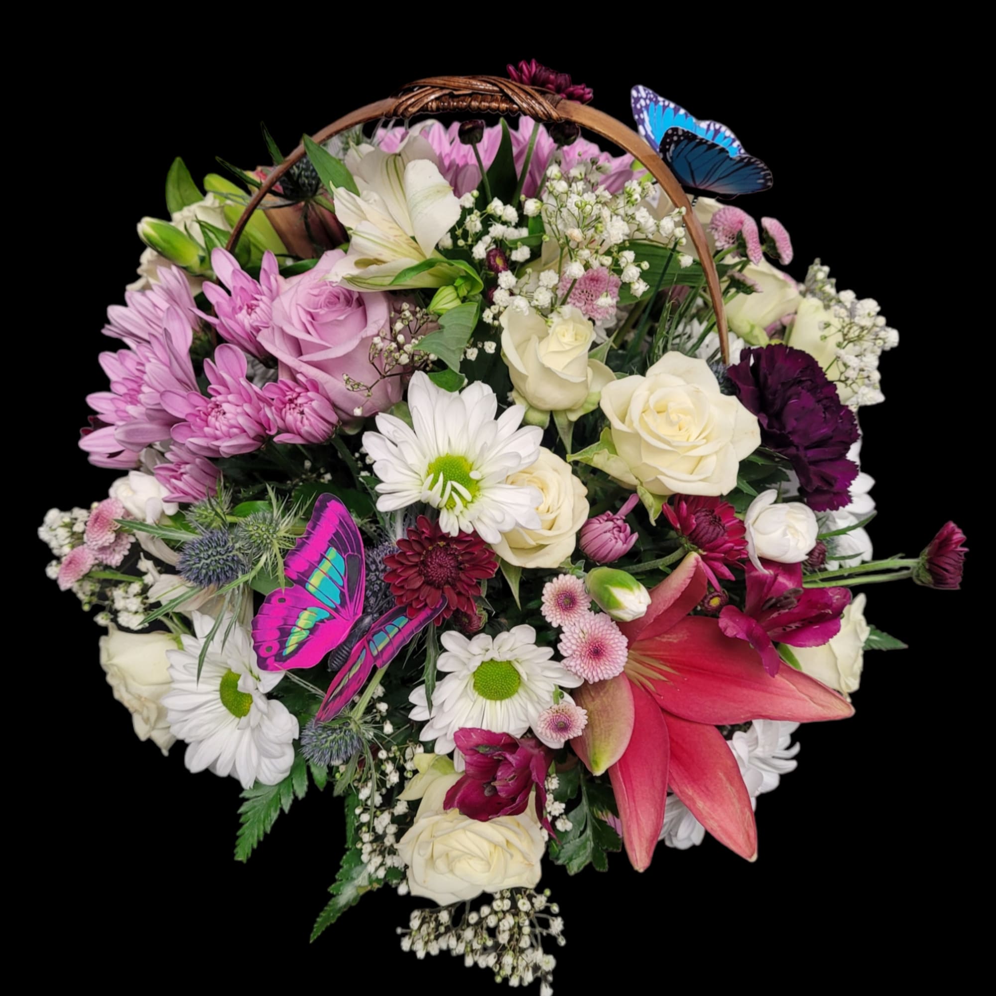 Basket arrangement of pink, white, and purple flowers with butterfly decorations