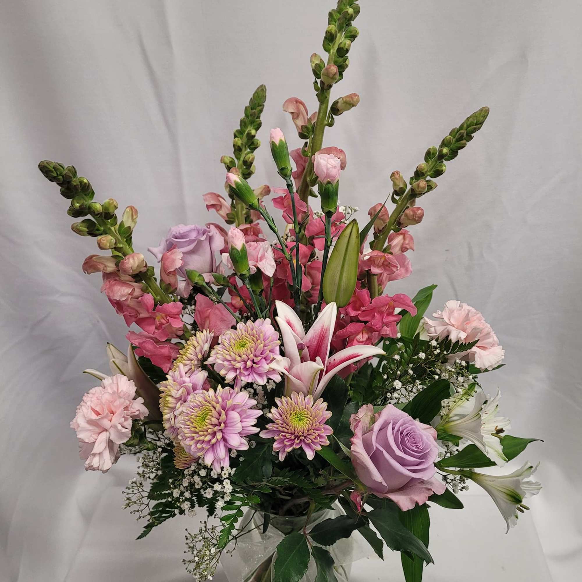 Pink and lavender mixed bouquet in a clear vase with lilies and roses