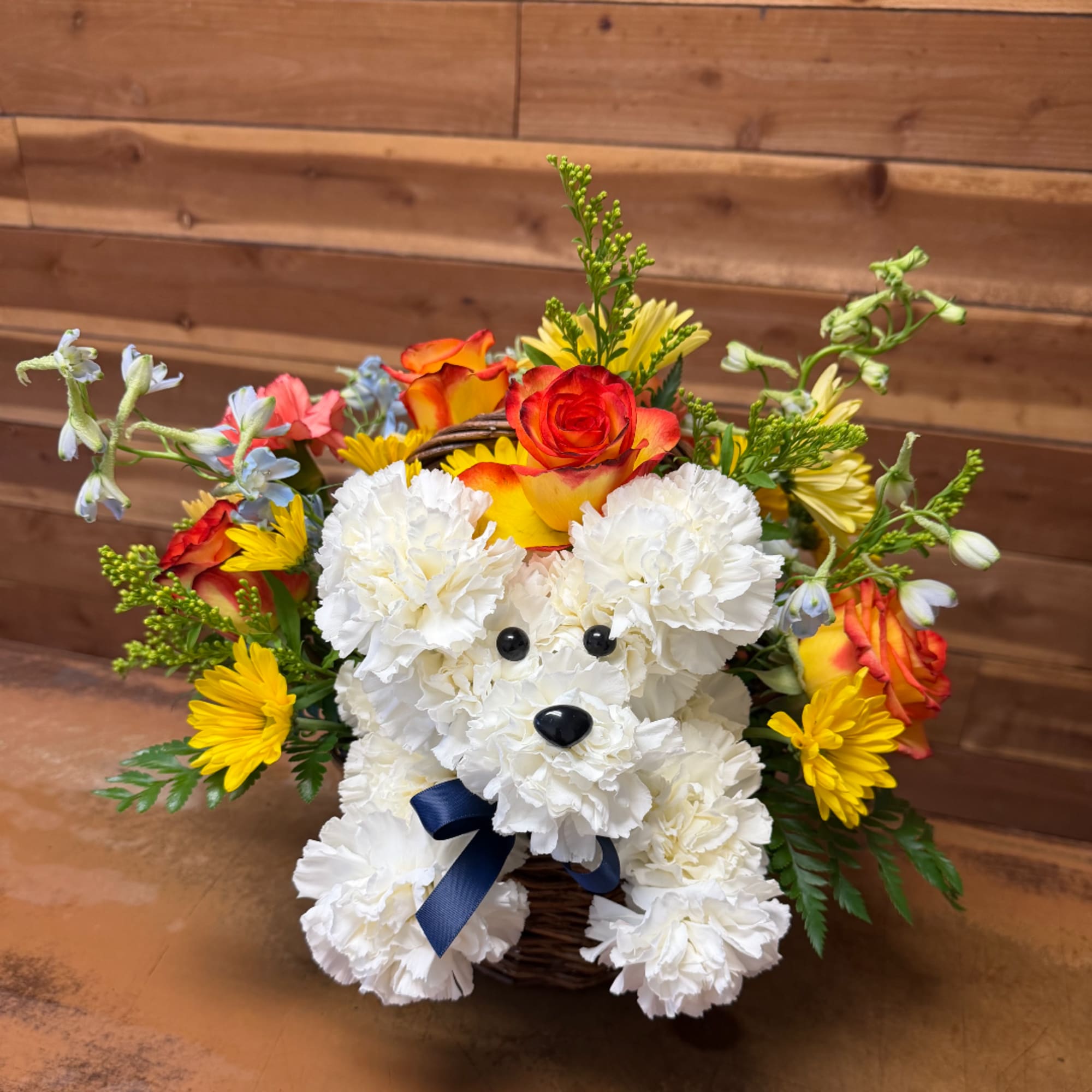 White teddy bear made of flowers in a basket with colorful blooms