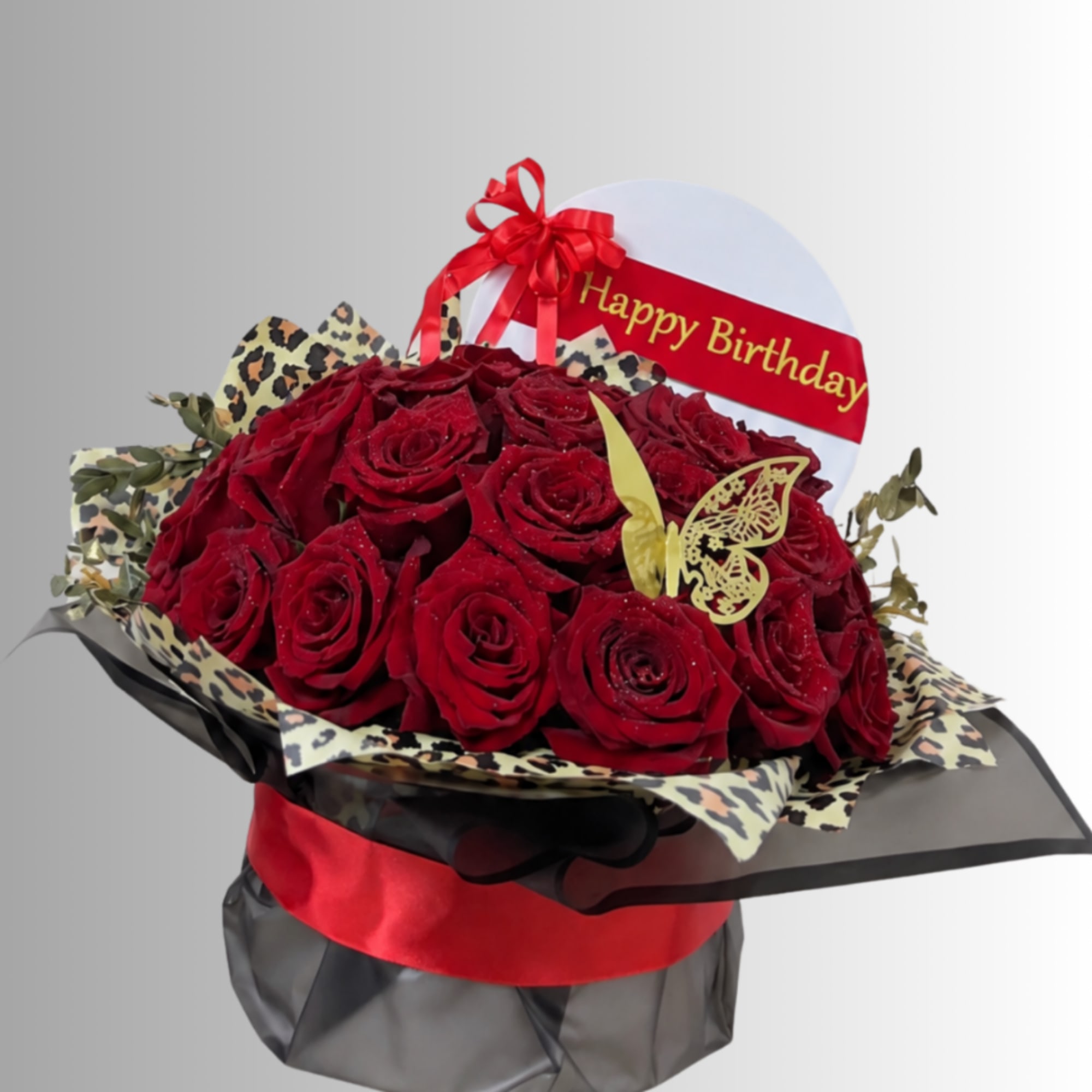 Bouquet of red roses with a Happy Birthday sign and ribbon